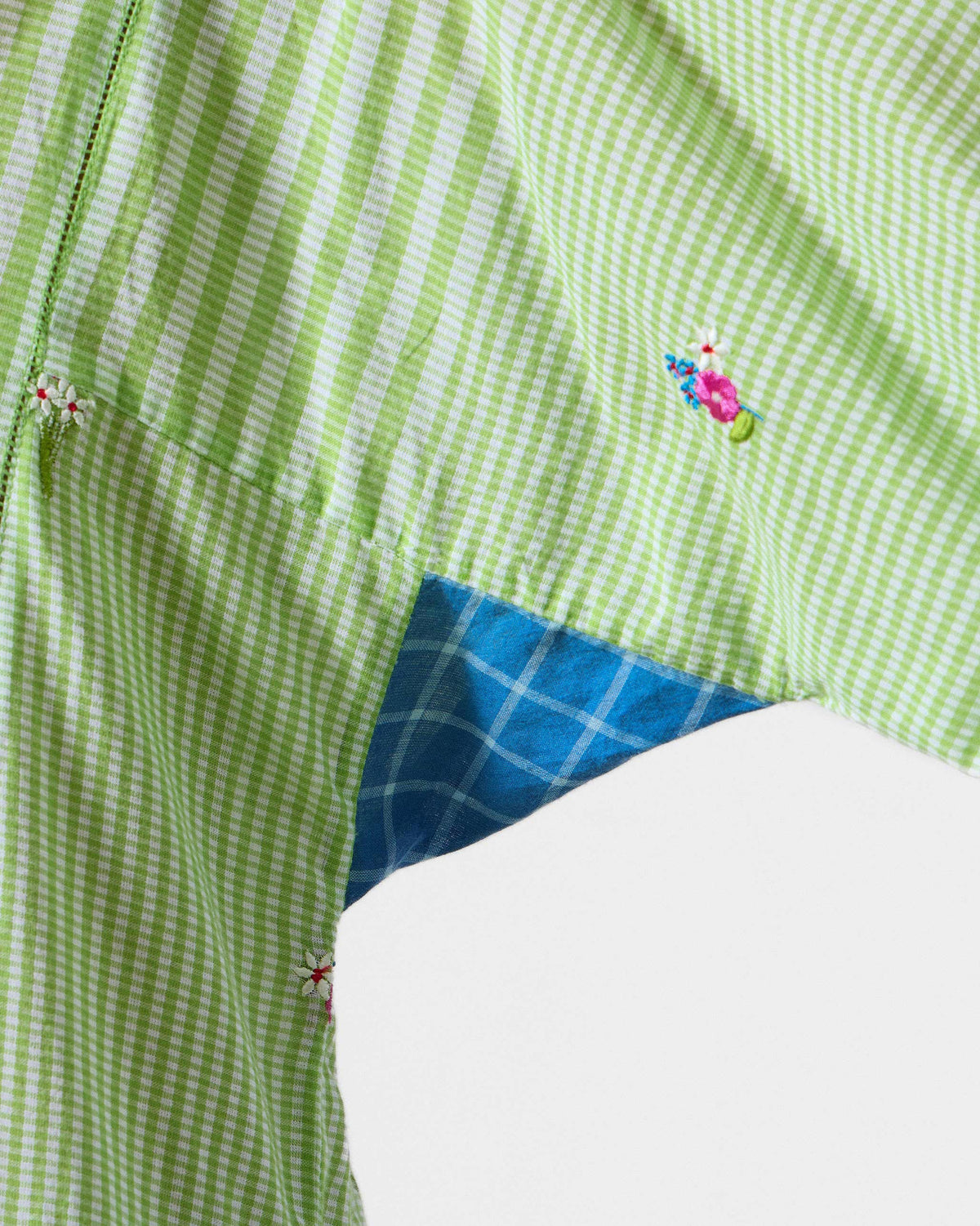 Close-up of a green and white Gigi Kurta showing floral embroidery and a check gusset.