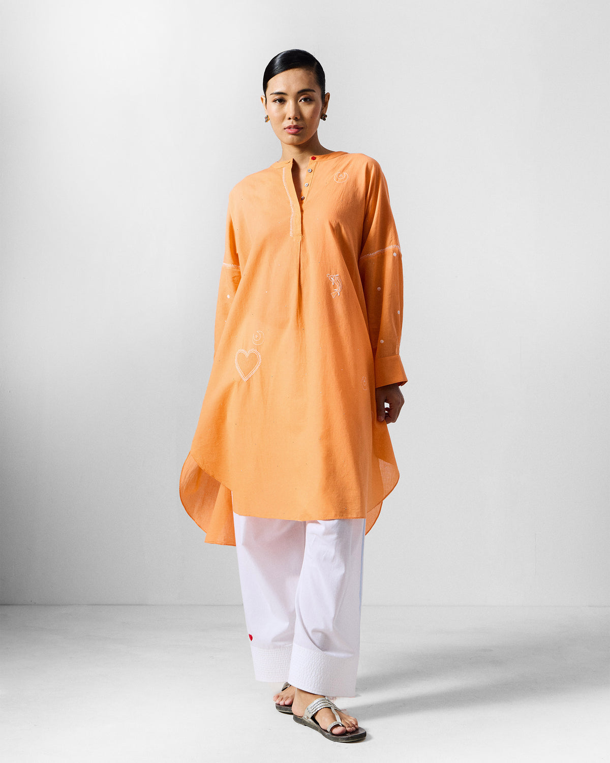 Orange Lazy Sunday tunic with white heart embroidery and a high-low hem.