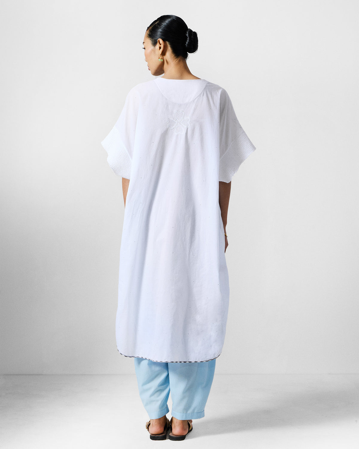 Back of a white Calicut kurta with short wide sleeves.