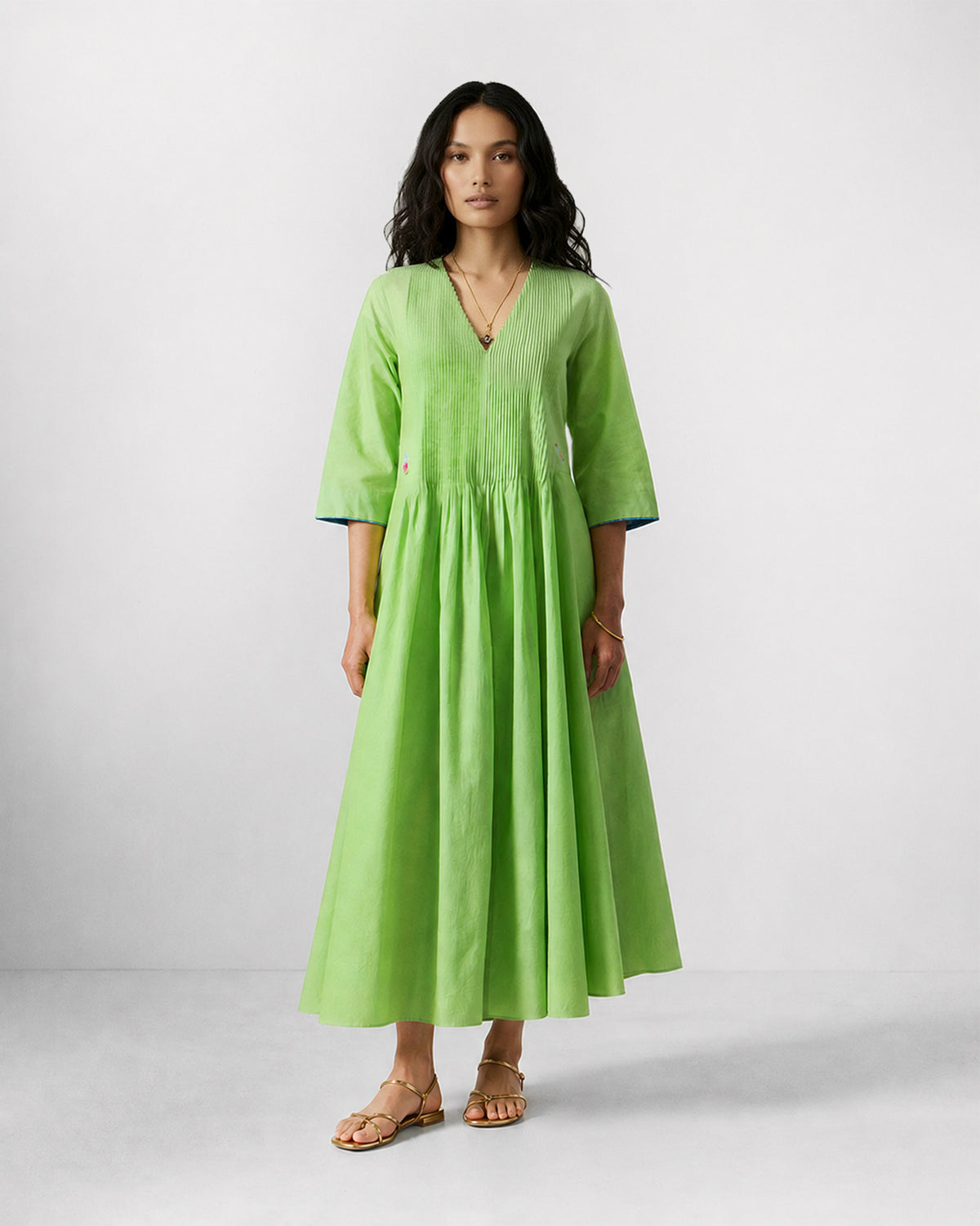 Person wearing a light green Yara dress with pin tucks across the bodice.