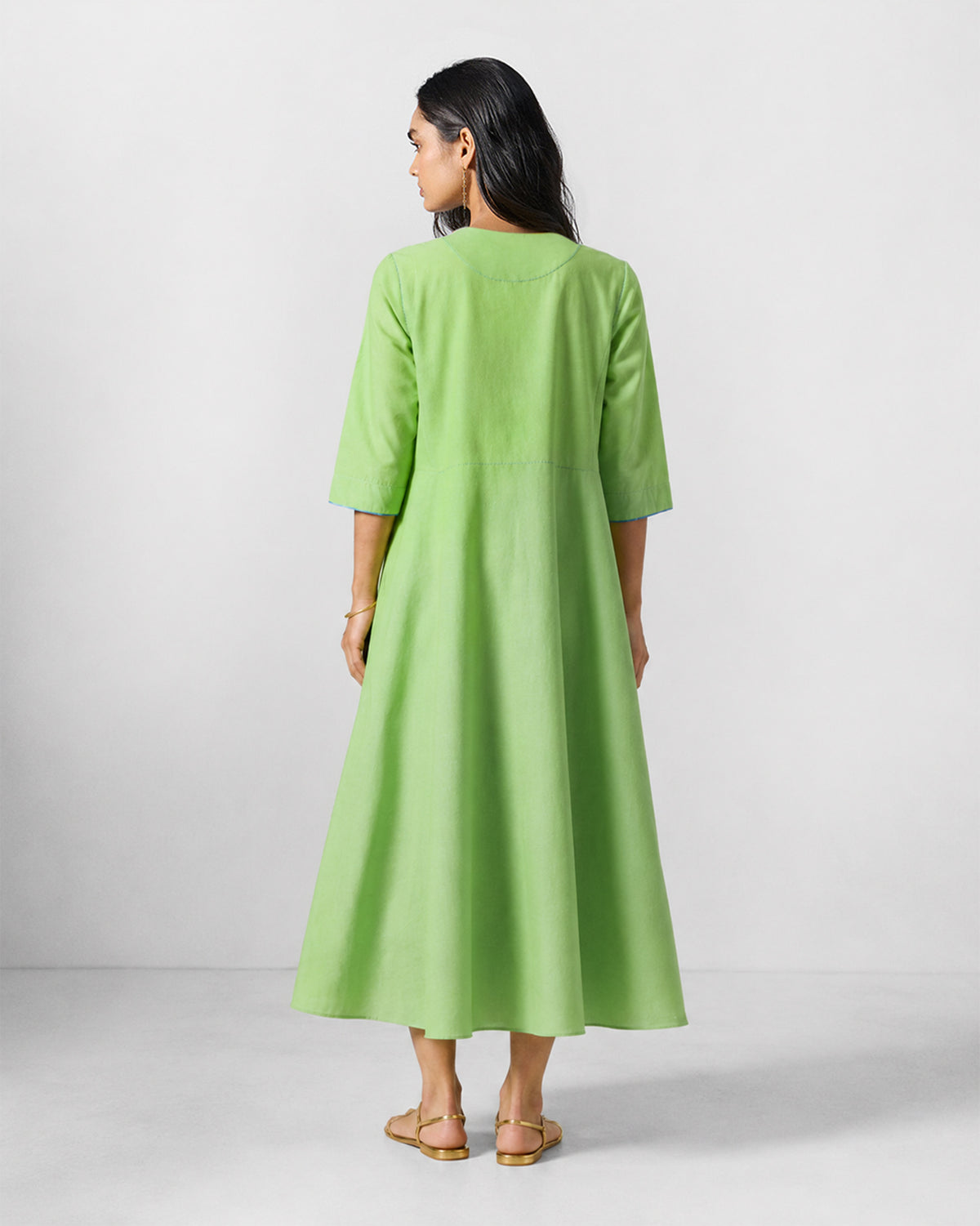 Back of a light green Yara dress worn by a person.