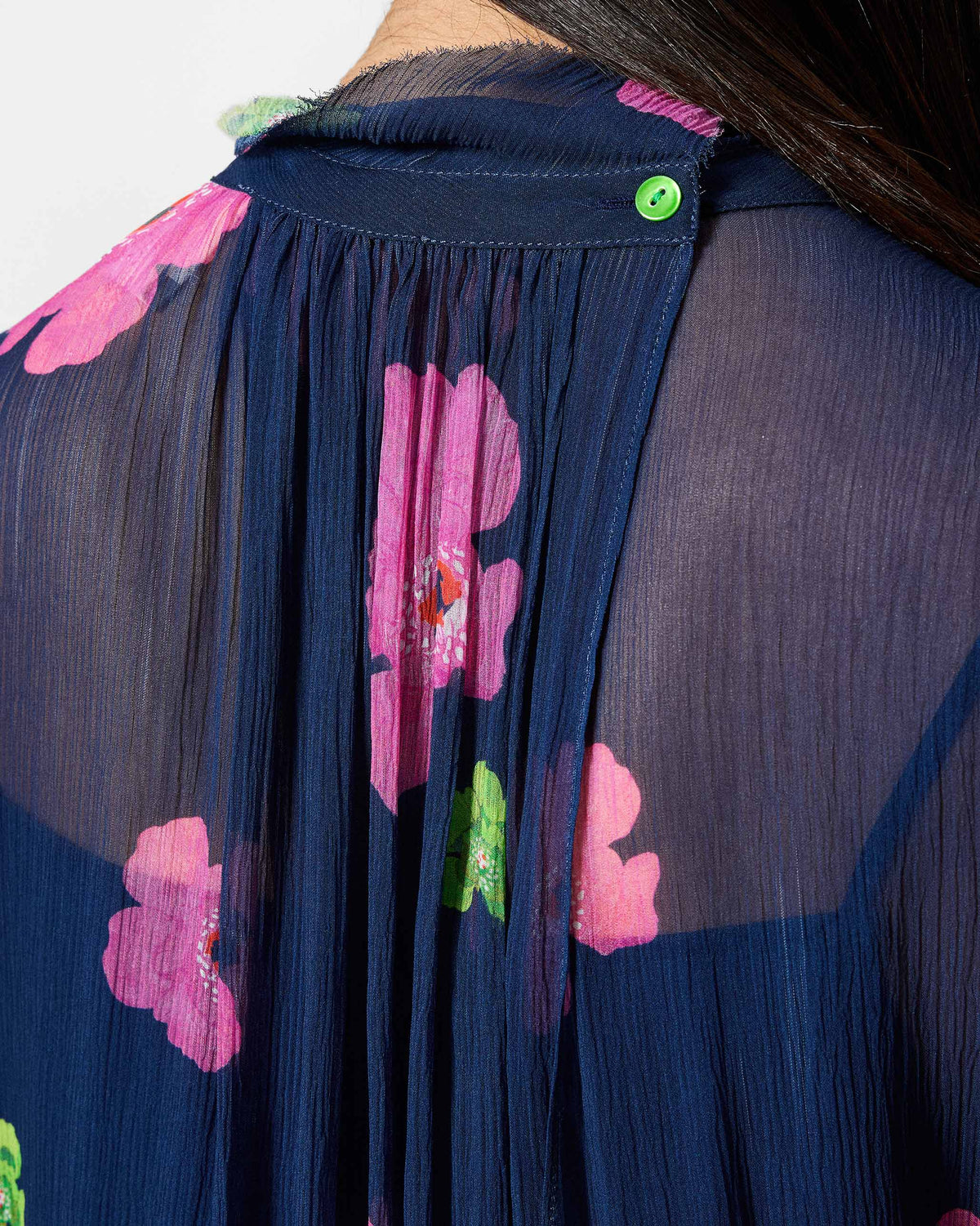 Close-up of the back neck button on a navy floral Raya dress.