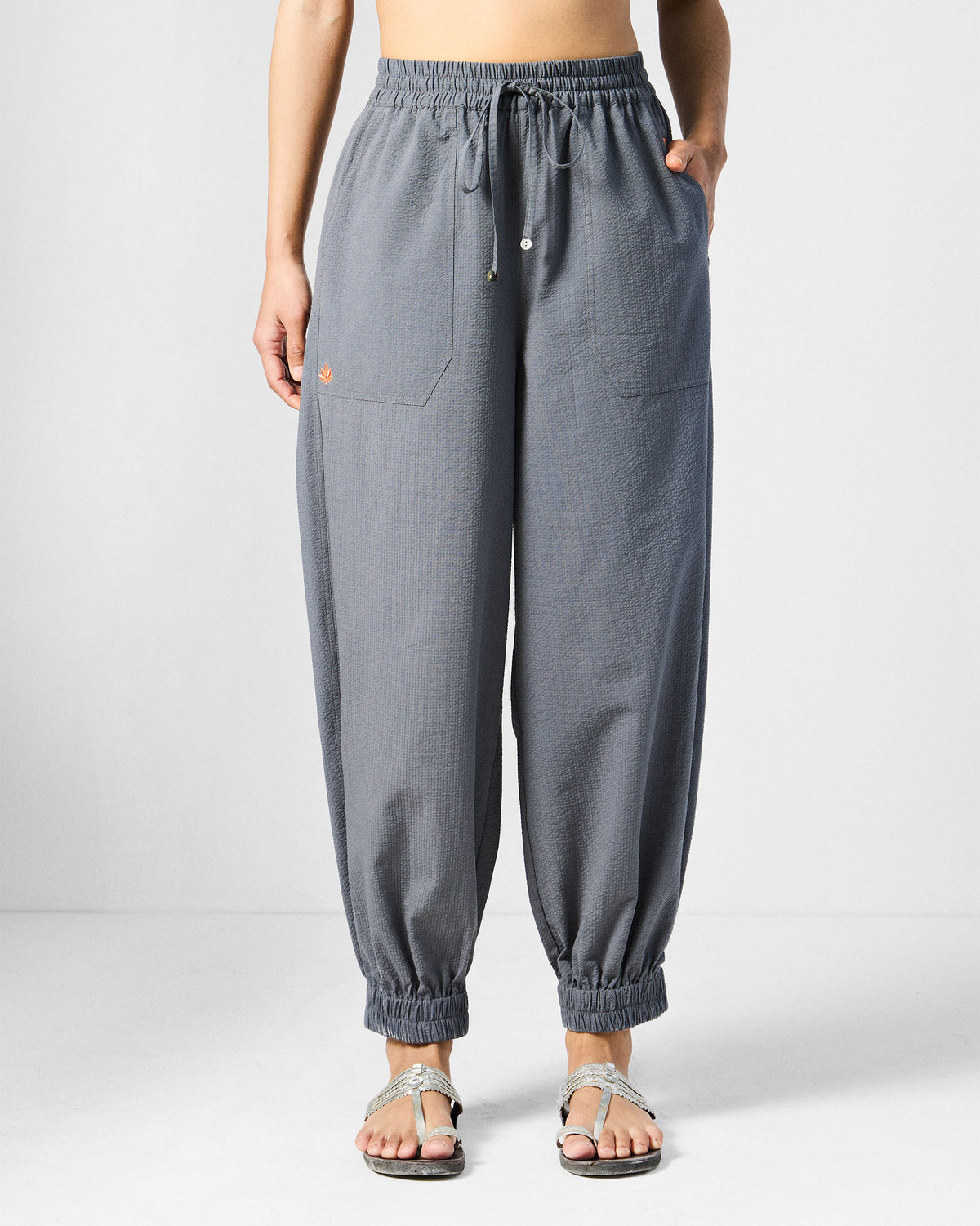 Person wearing charcoal joggers with patch pockets and elastic cuffs.
