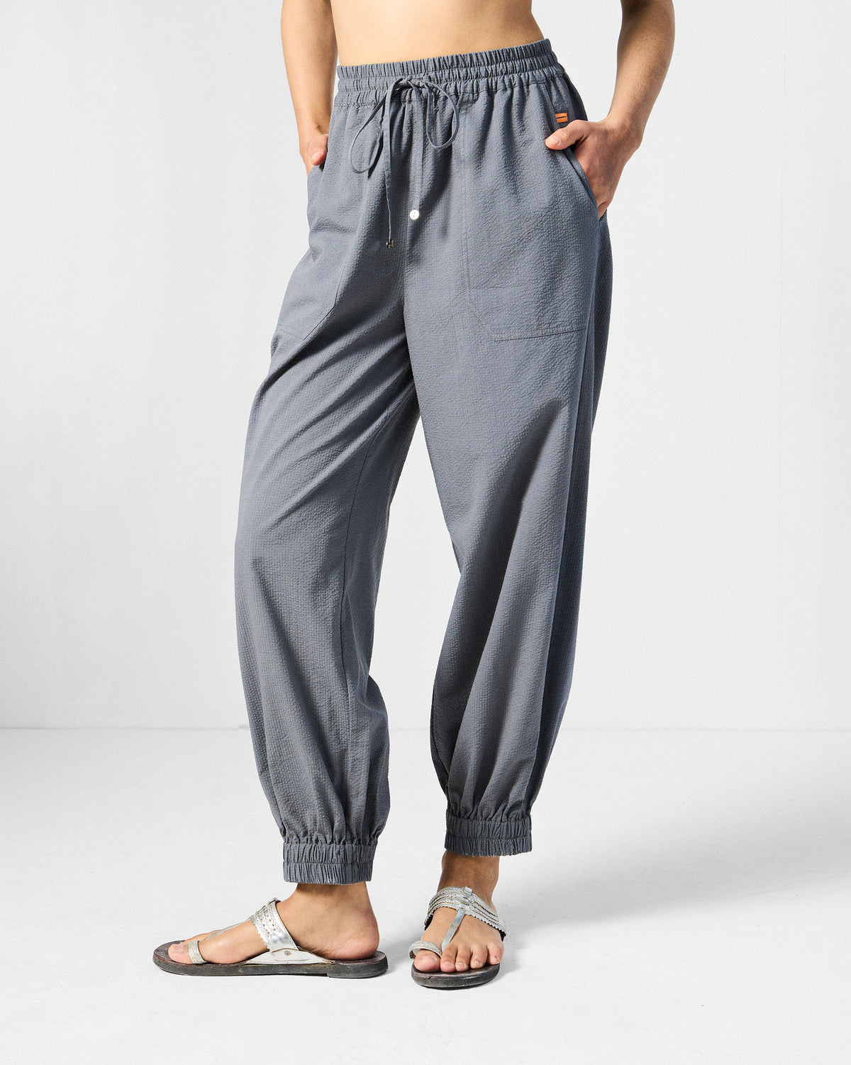Person wearing charcoal joggers with a drawstring waist.