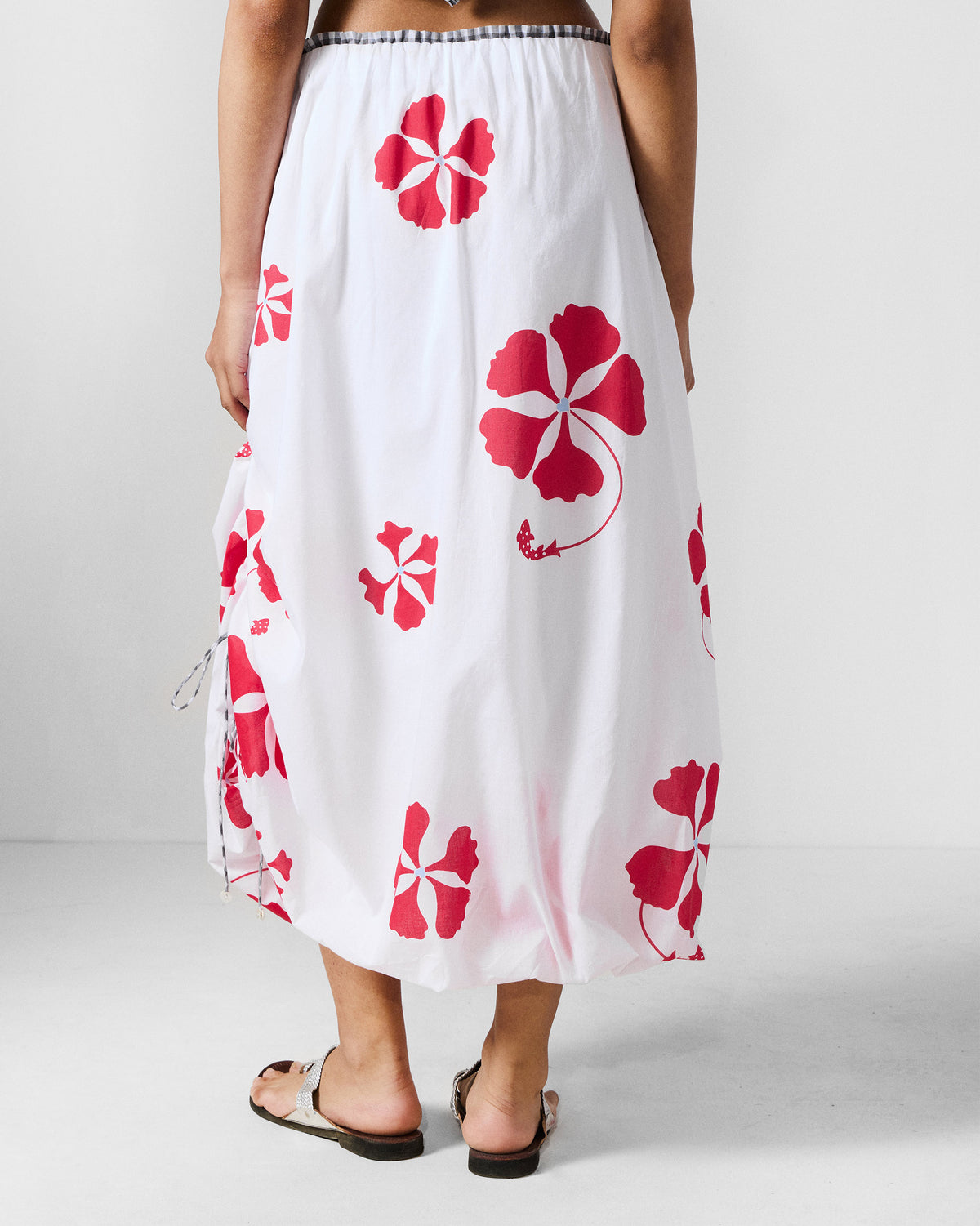Back of a white Billow Skirt with a red gulmohar print.
