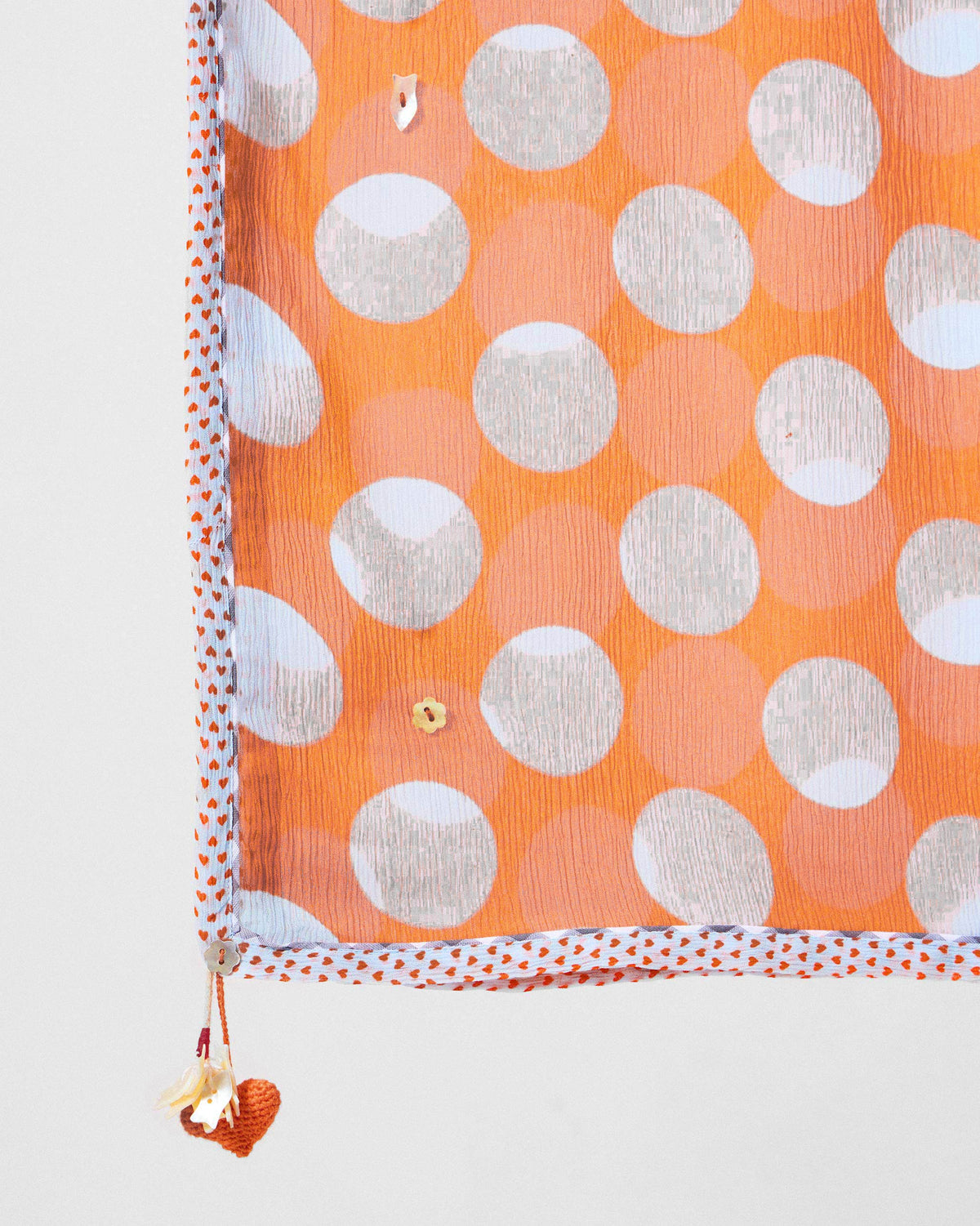 Close-up of a Dot dupatta corner with white polka dots and a tassel.