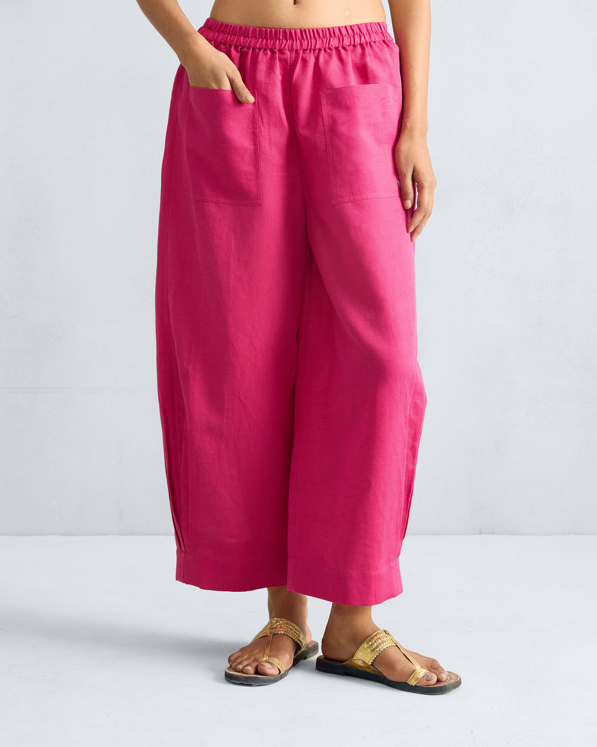 Person wearing fuchsia Serene pants with front patch pockets.