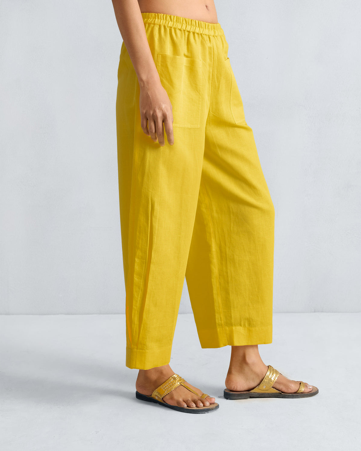 Side view of yellow Serene pants showing a cropped wide-leg fit and patch pocket.