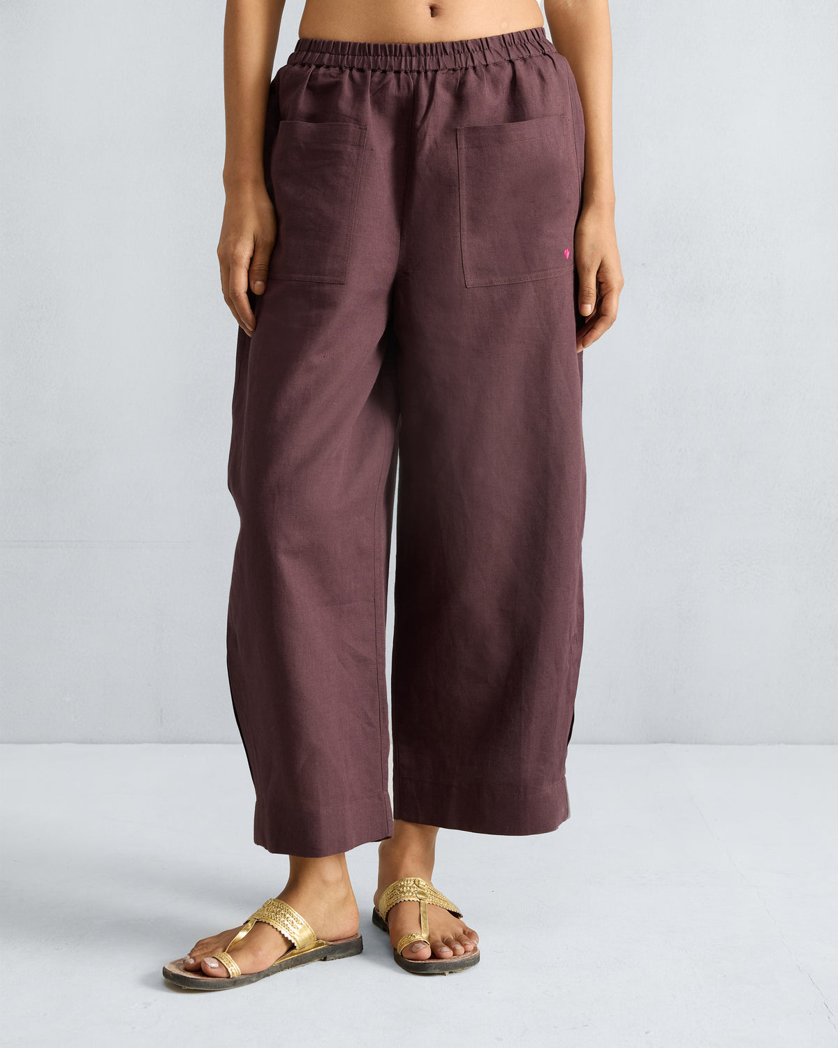 Person wearing chocolate plum Serene pants with front patch pockets.