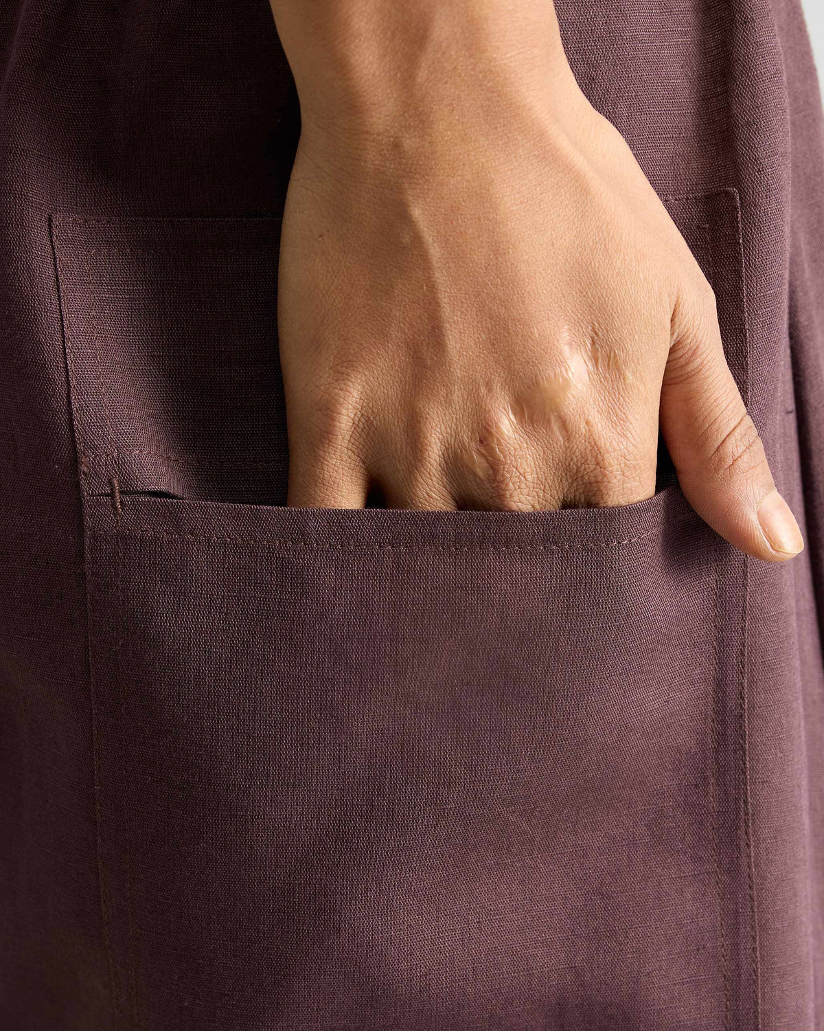Close-up of a deep patch pocket on chocolate plum Yoka Trousers.