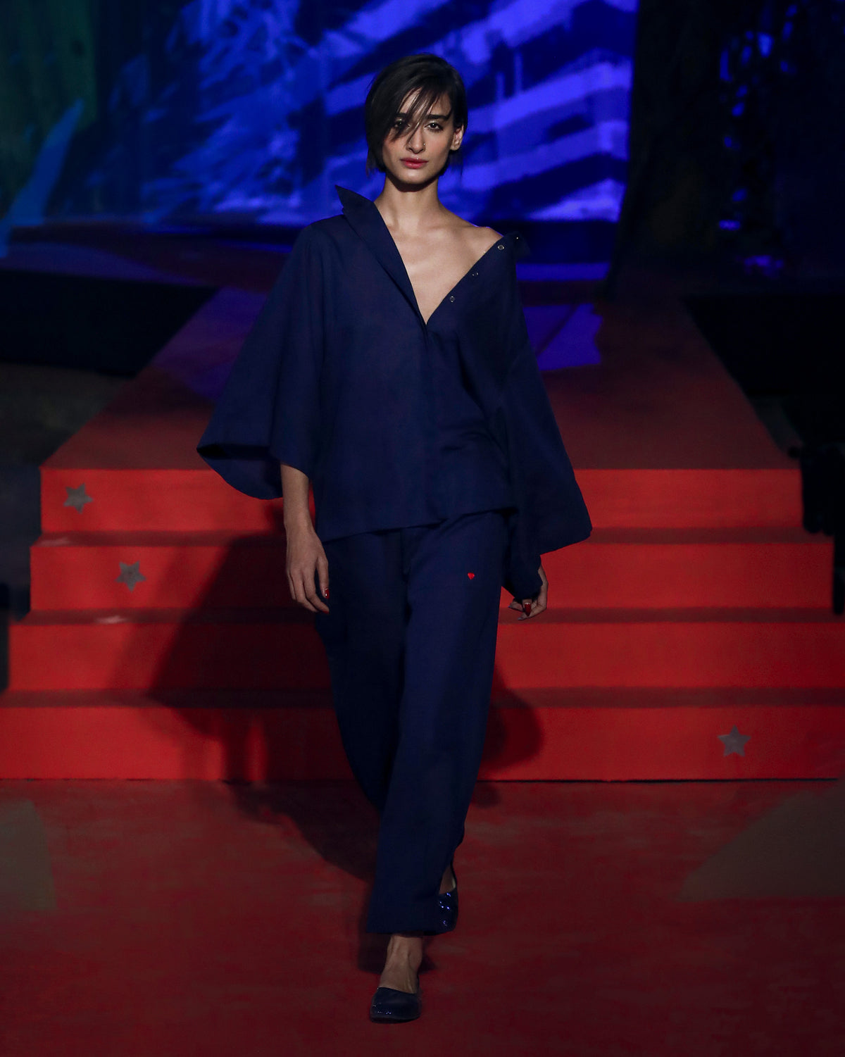 Person wearing an ink blue drop armhole shirt with wide sleeves.