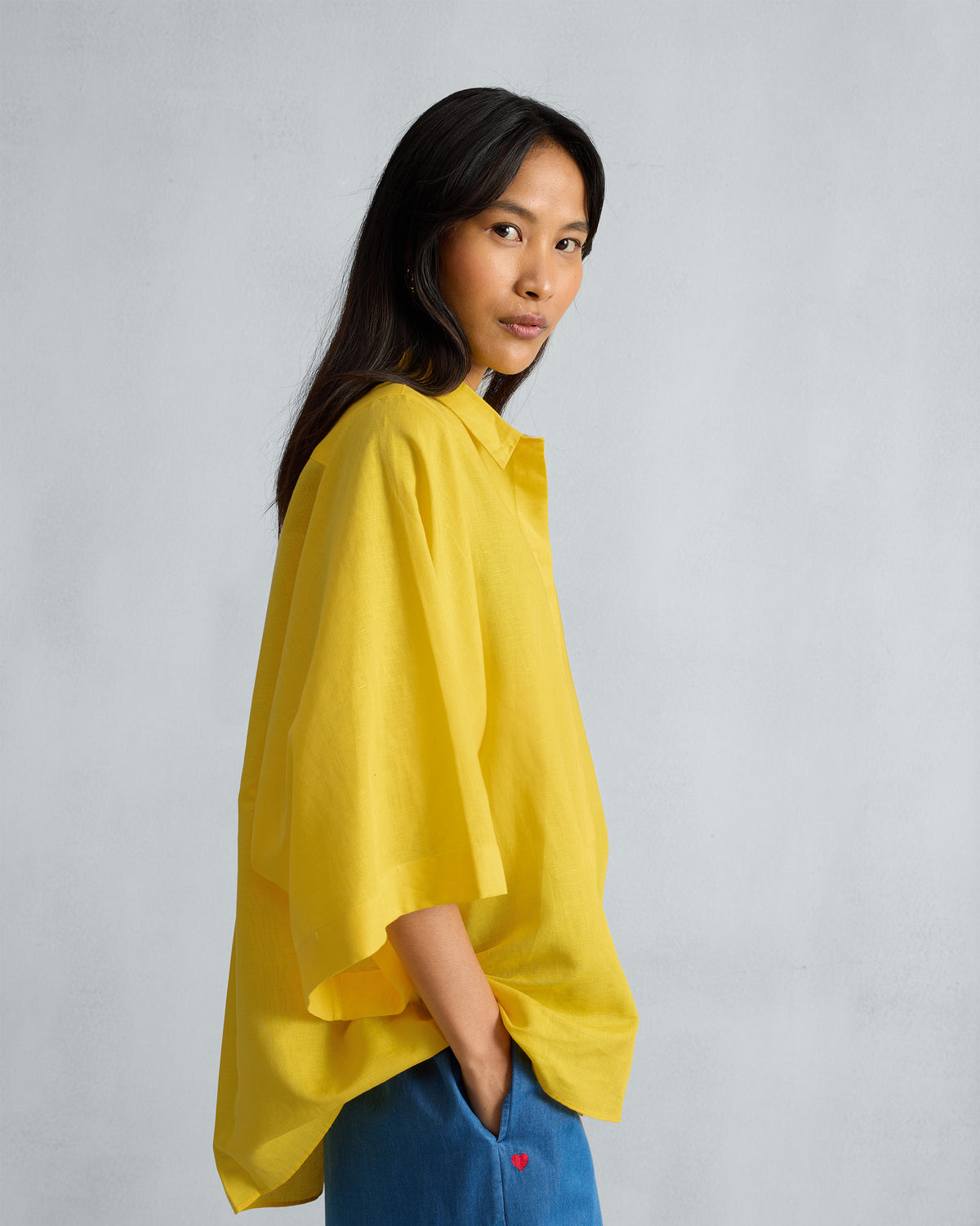 Side view of a yellow Drop Armhole Shirt with wide sleeves.