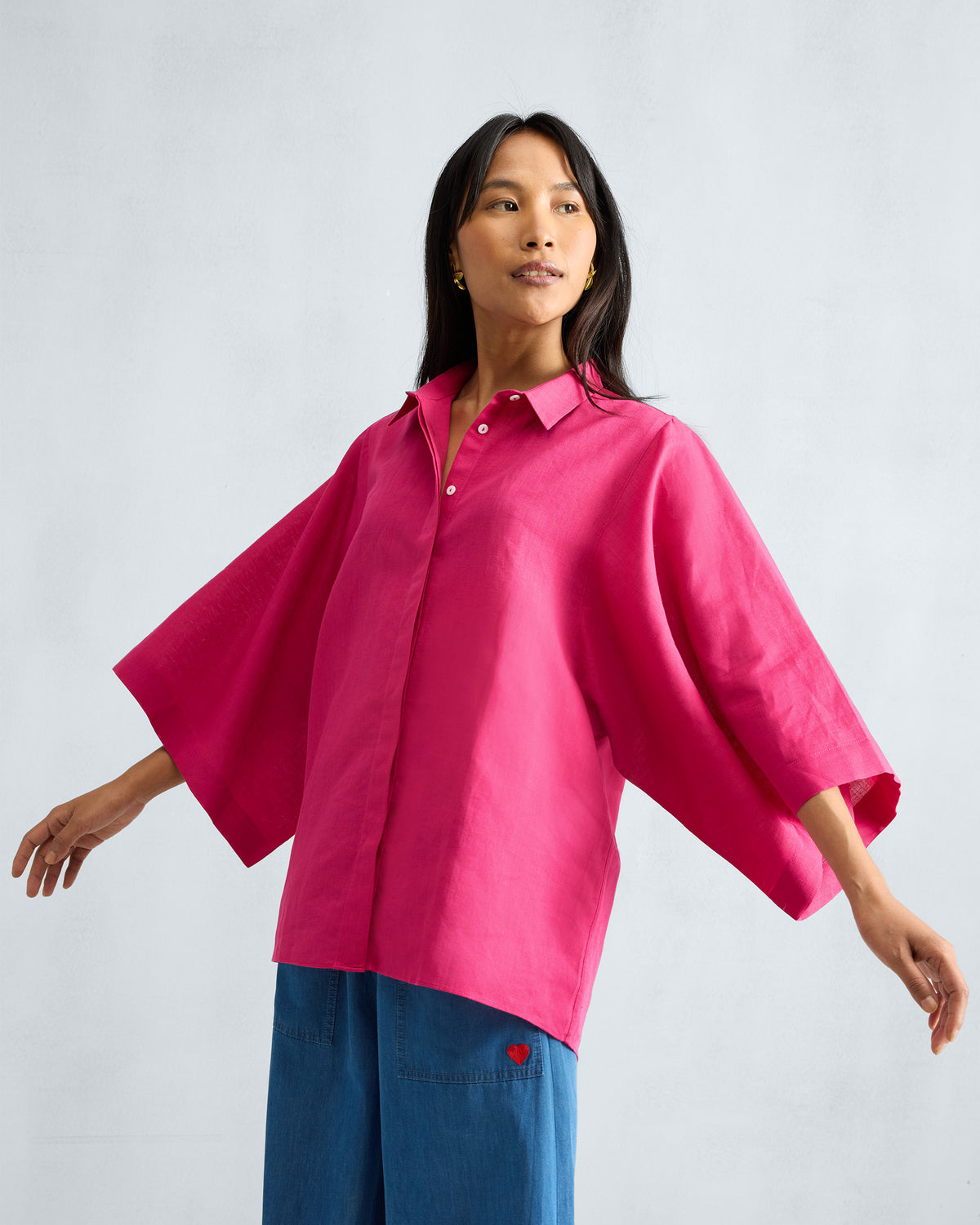 Person wearing a fuchsia Drop Armhole Shirt with flared wide sleeves.