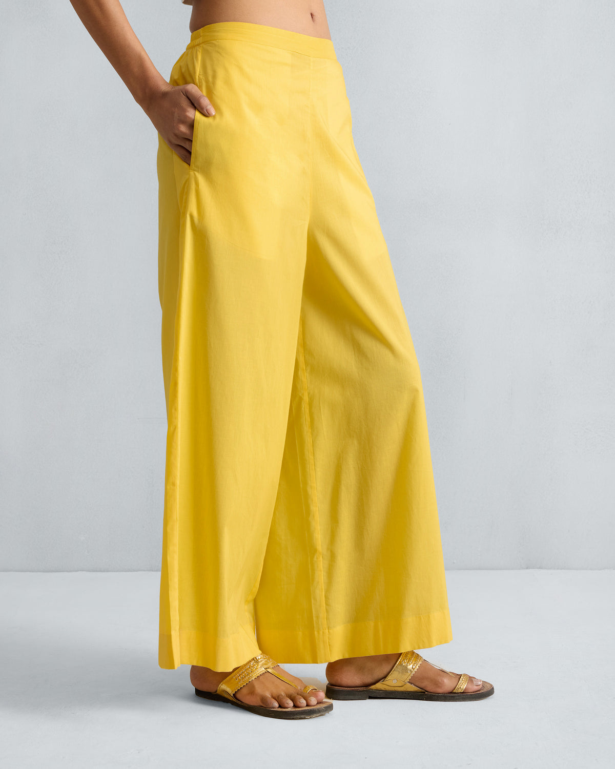 Side view of yellow Basic Pyjamas with a hand in the side pocket.