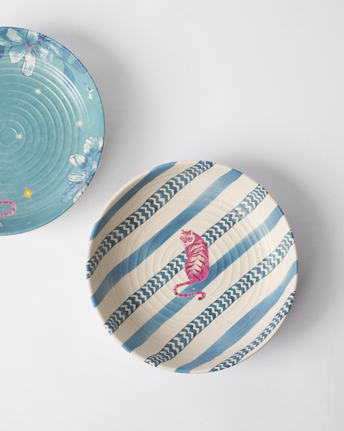 Close-up of a River Tiger shallow bowl with blue stripes and a pink tiger.