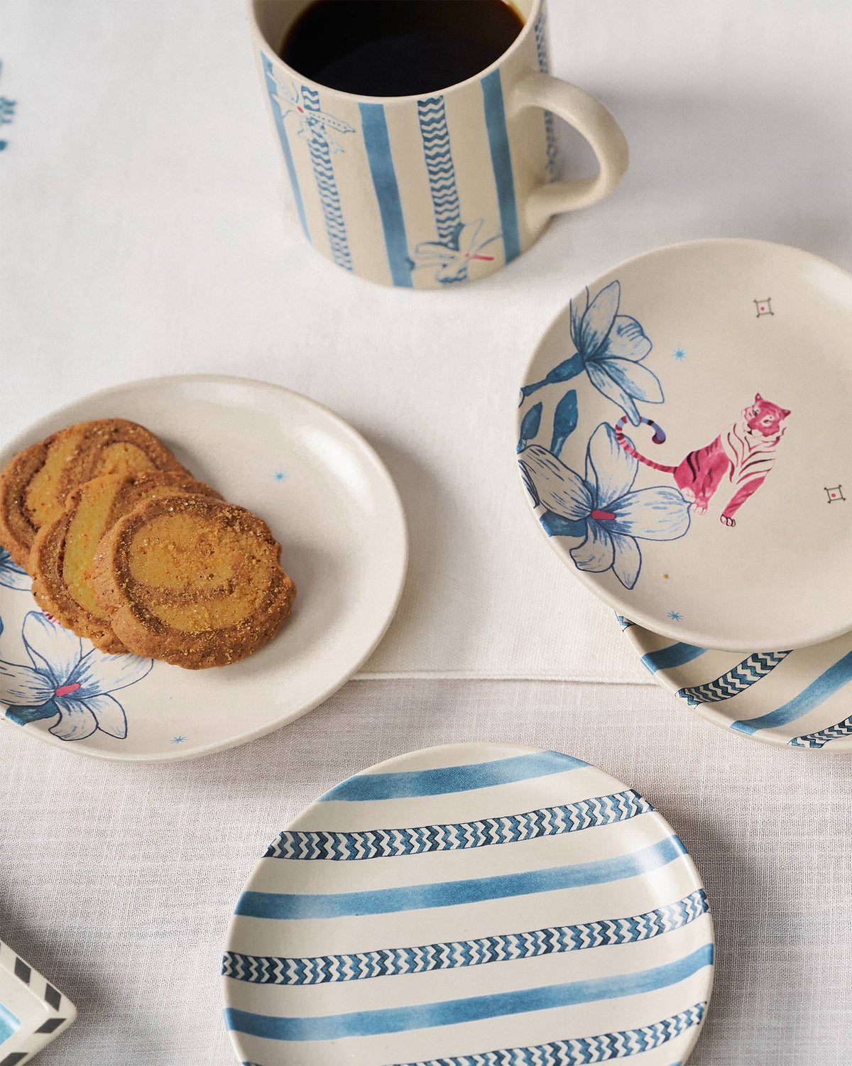 River Tiger tea plates with cookies and a striped coffee mug.