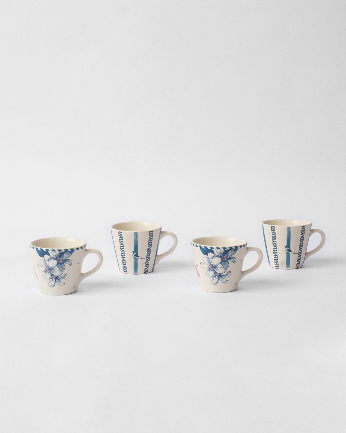 Four River Tiger espresso mugs alternating blue floral and striped bird prints.