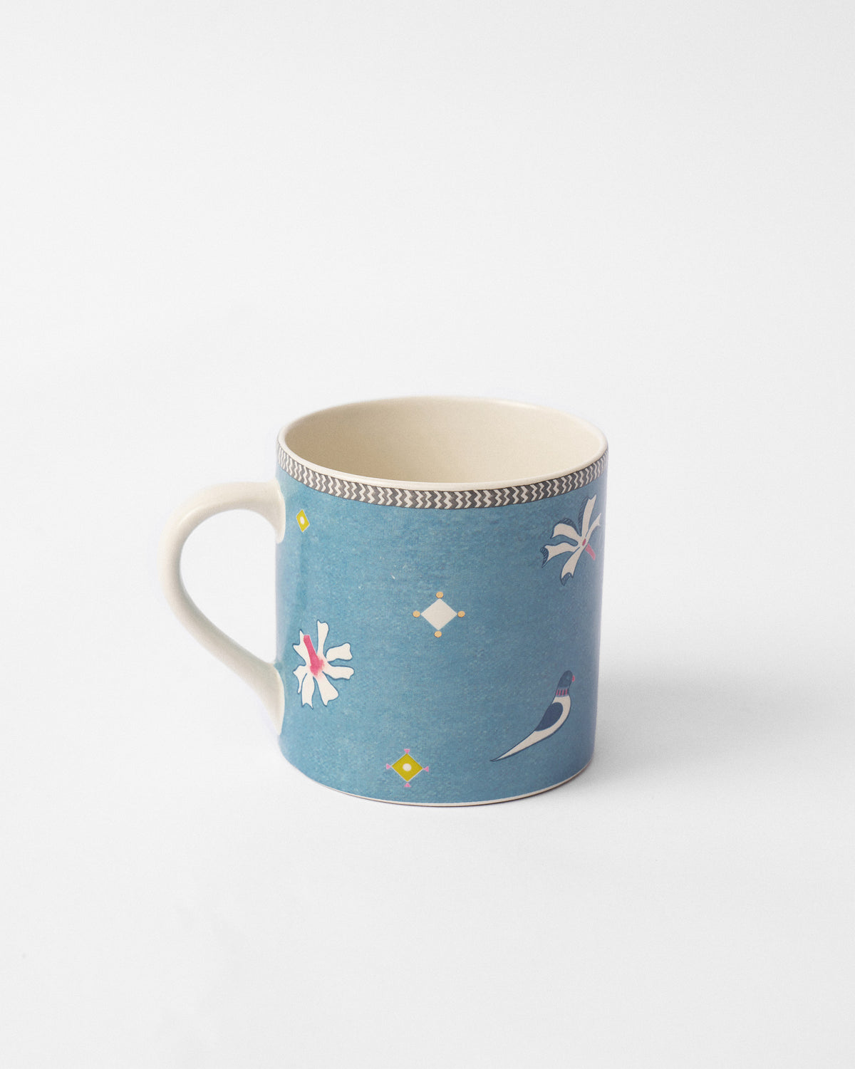 Side view of the Parijat straight mug with its handle on the left and a bird motif.