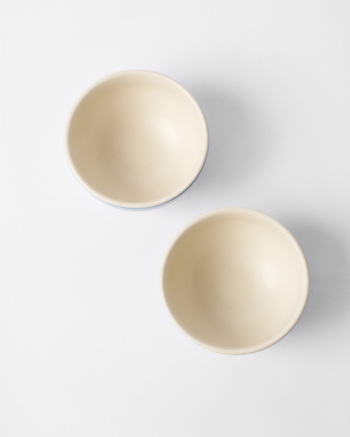 Overhead view of two Marigold nibble bowls showing cream interiors.