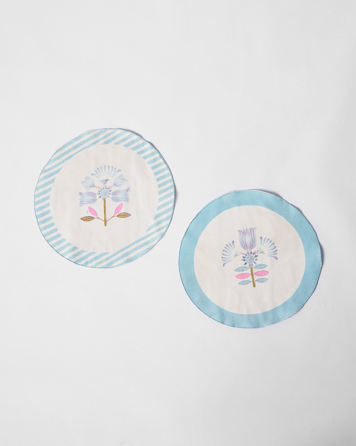 Pair of Lotus Placemats with blue borders and a blue flower motif.