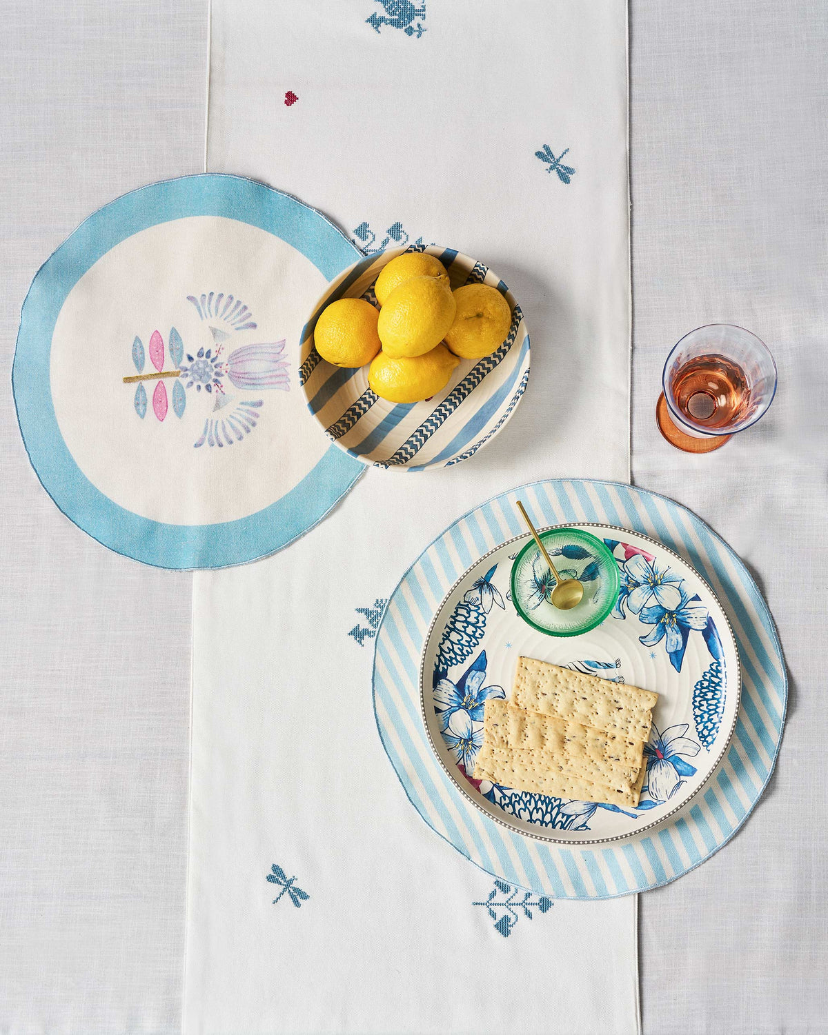 Lotus Placemat with a blue flower motif, shown on a dining table.