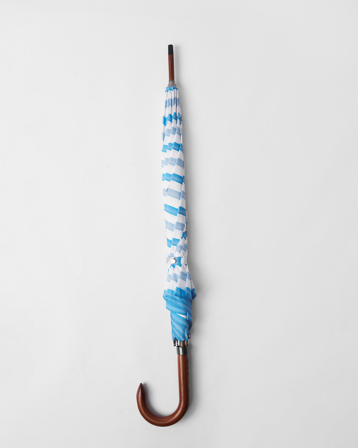 River Umbrella closed, with blue and white stripes and a wooden crook handle.