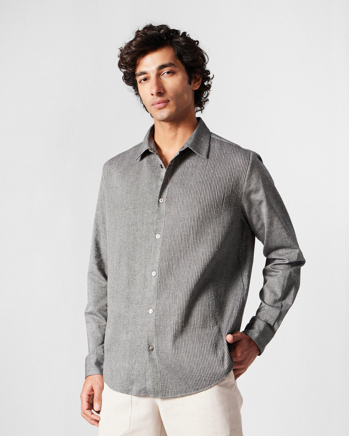 Person wearing a charcoal Nava shirt with a vertical pintuck panel down the front.