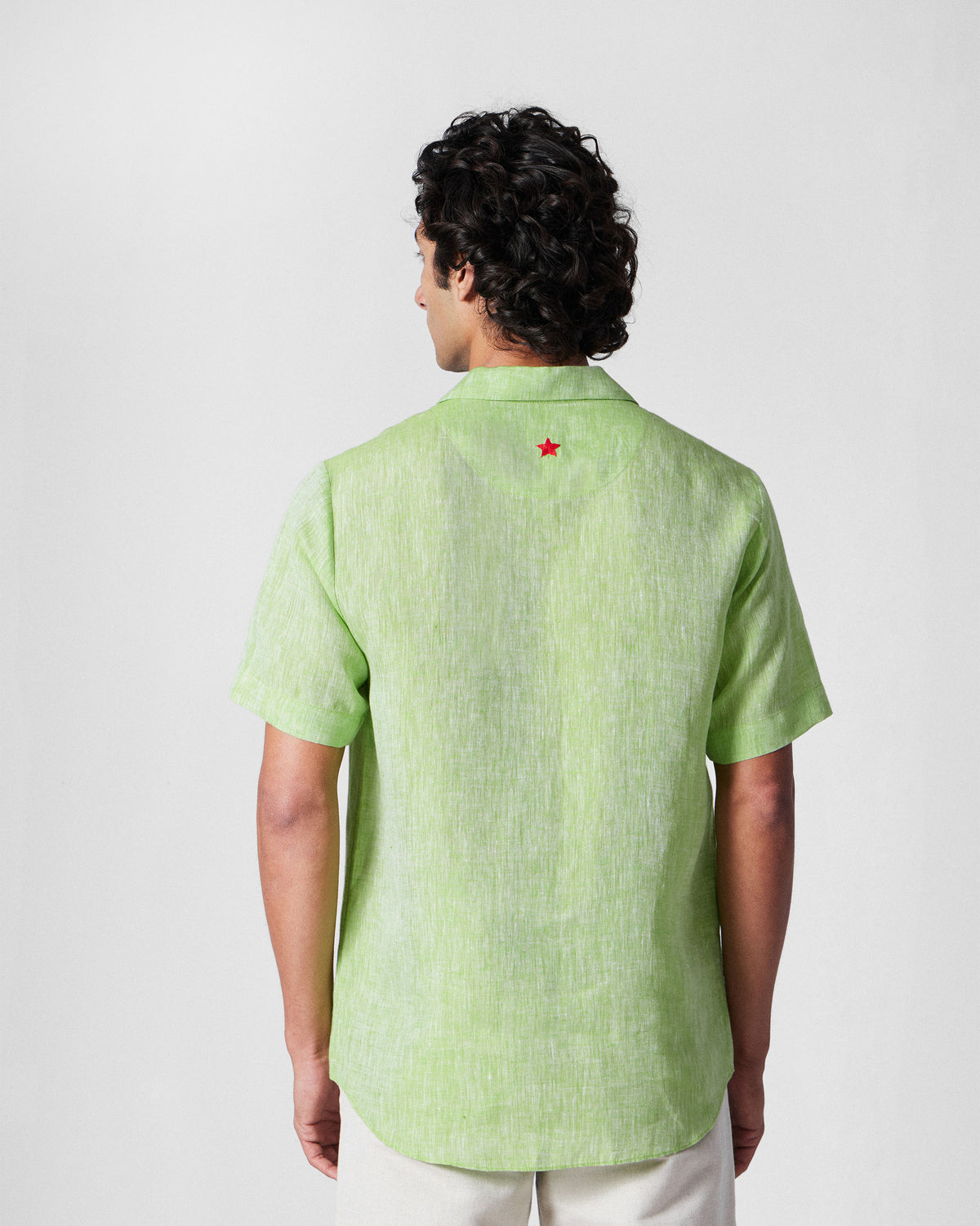 Back of a light green Mistari shirt with a red star at the yoke.