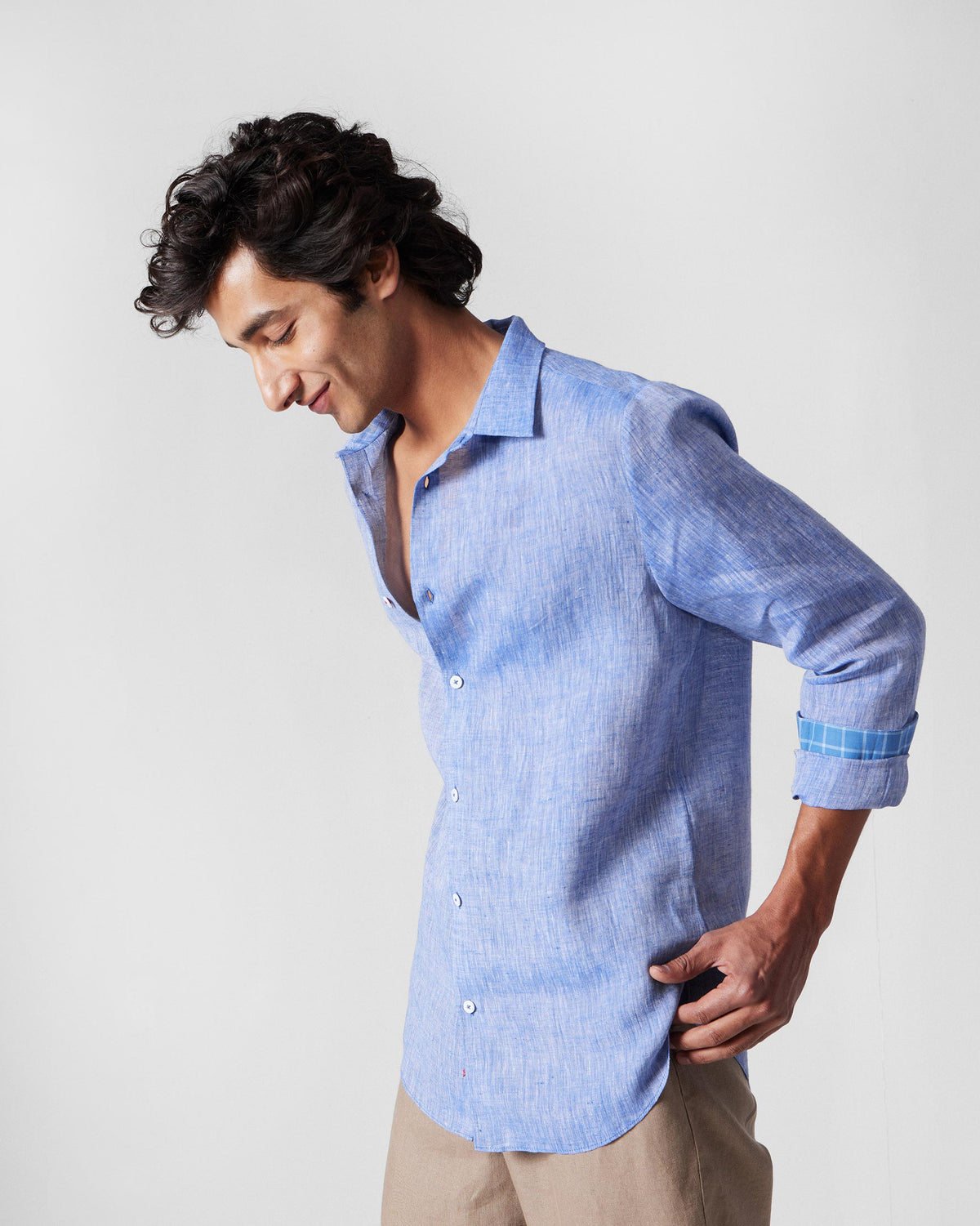 Side view of a light blue Hakuna Shirt with checkered cuff lining.