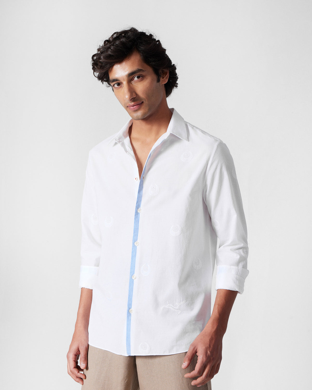 Person wearing a white Basalt shirt with chaand embroidery.