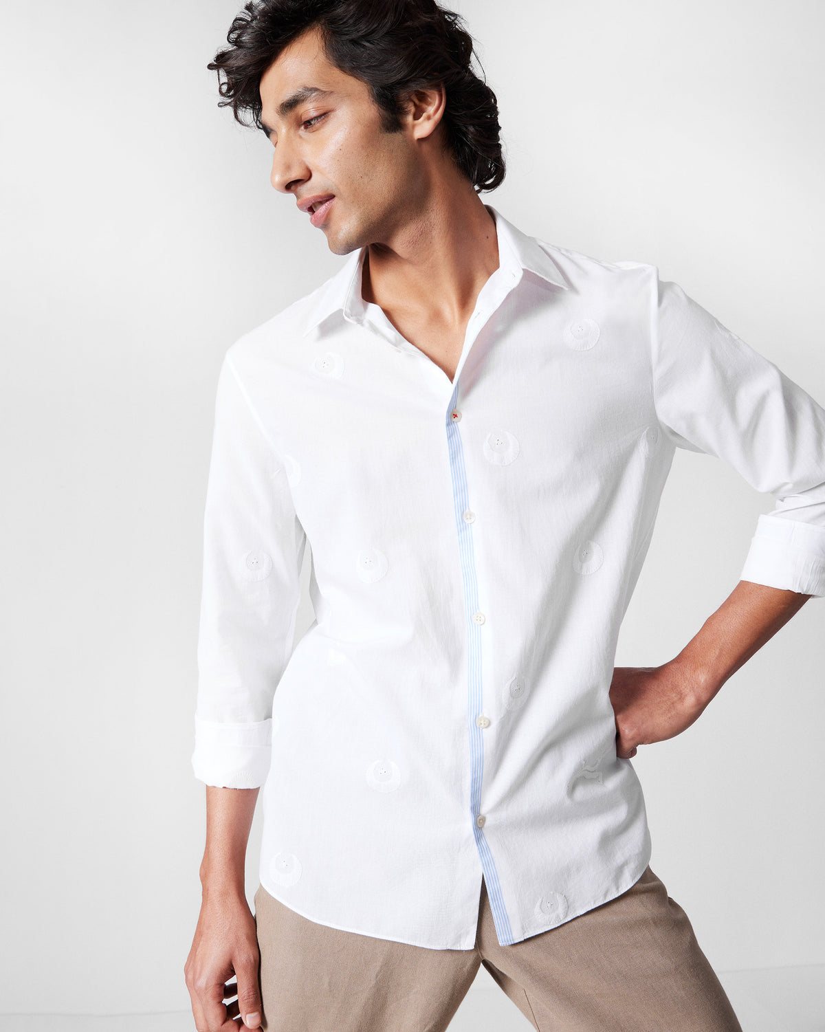 Person wearing a white Basalt shirt with tonal embroidery.