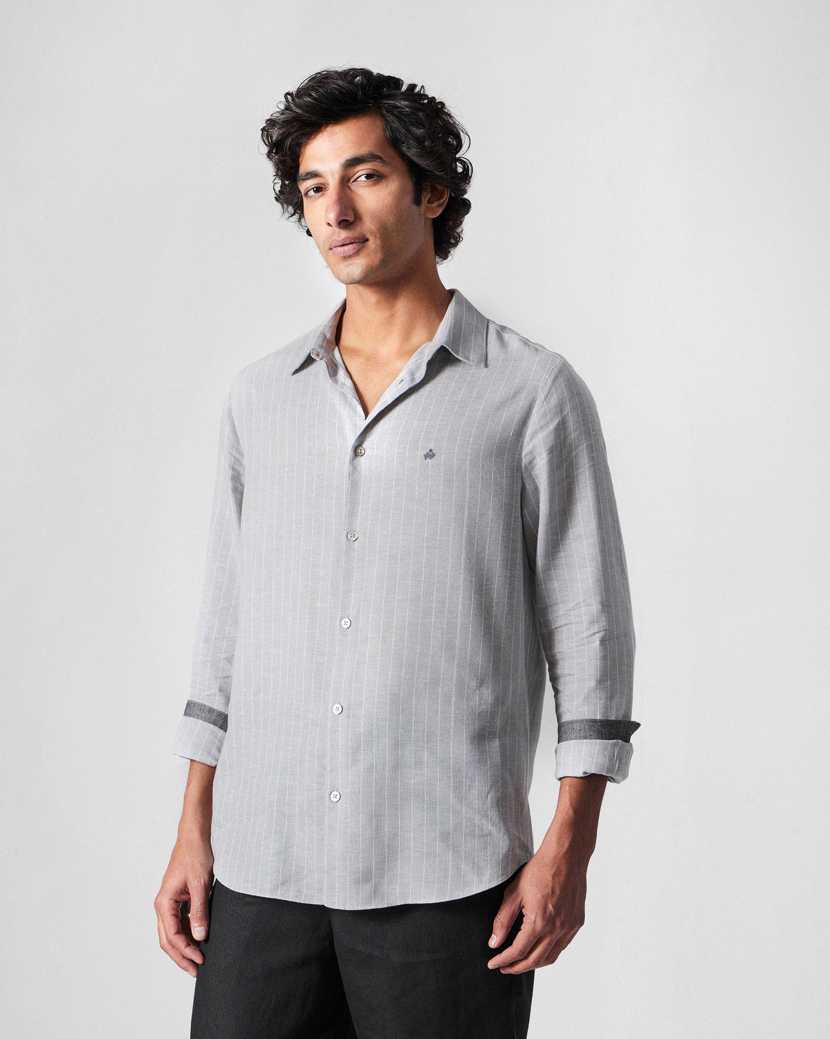 Person wearing a charcoal striped Silas Shirt with dark cuff lining.