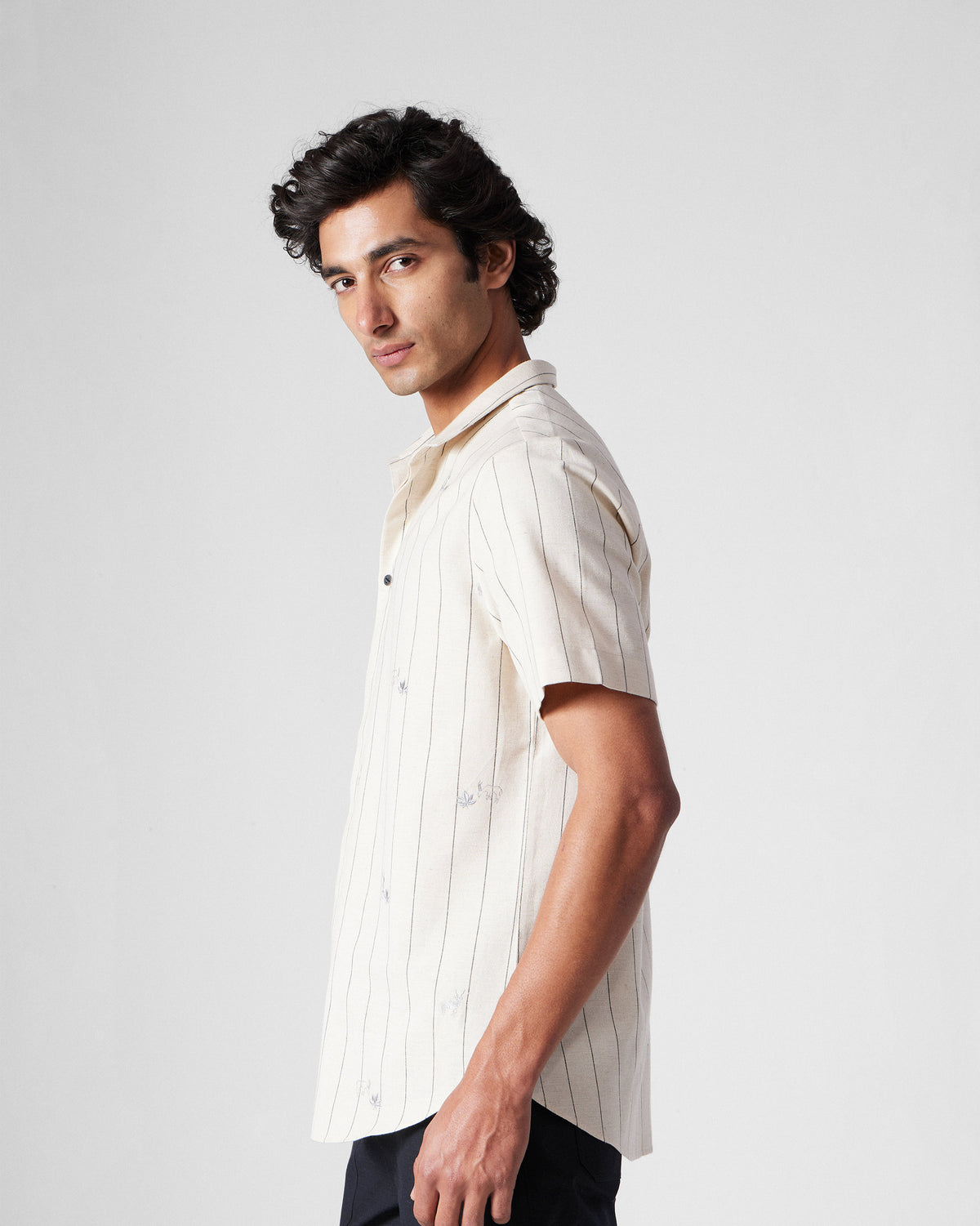 Side view of an ivory Riverine Shirt with charcoal stripes and embroidery.