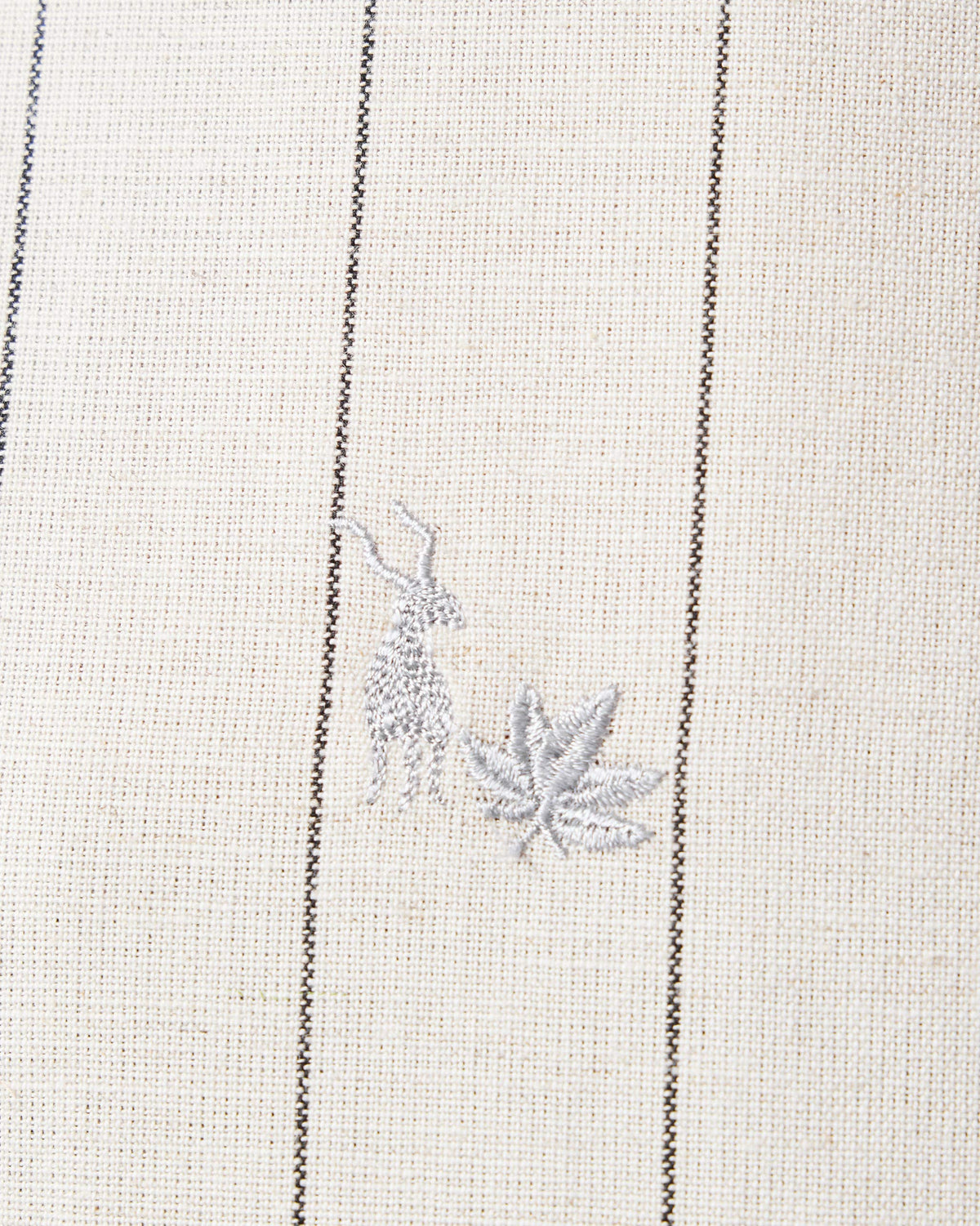 Close-up of antelope and leaf embroidery on an ivory Riverine Shirt.