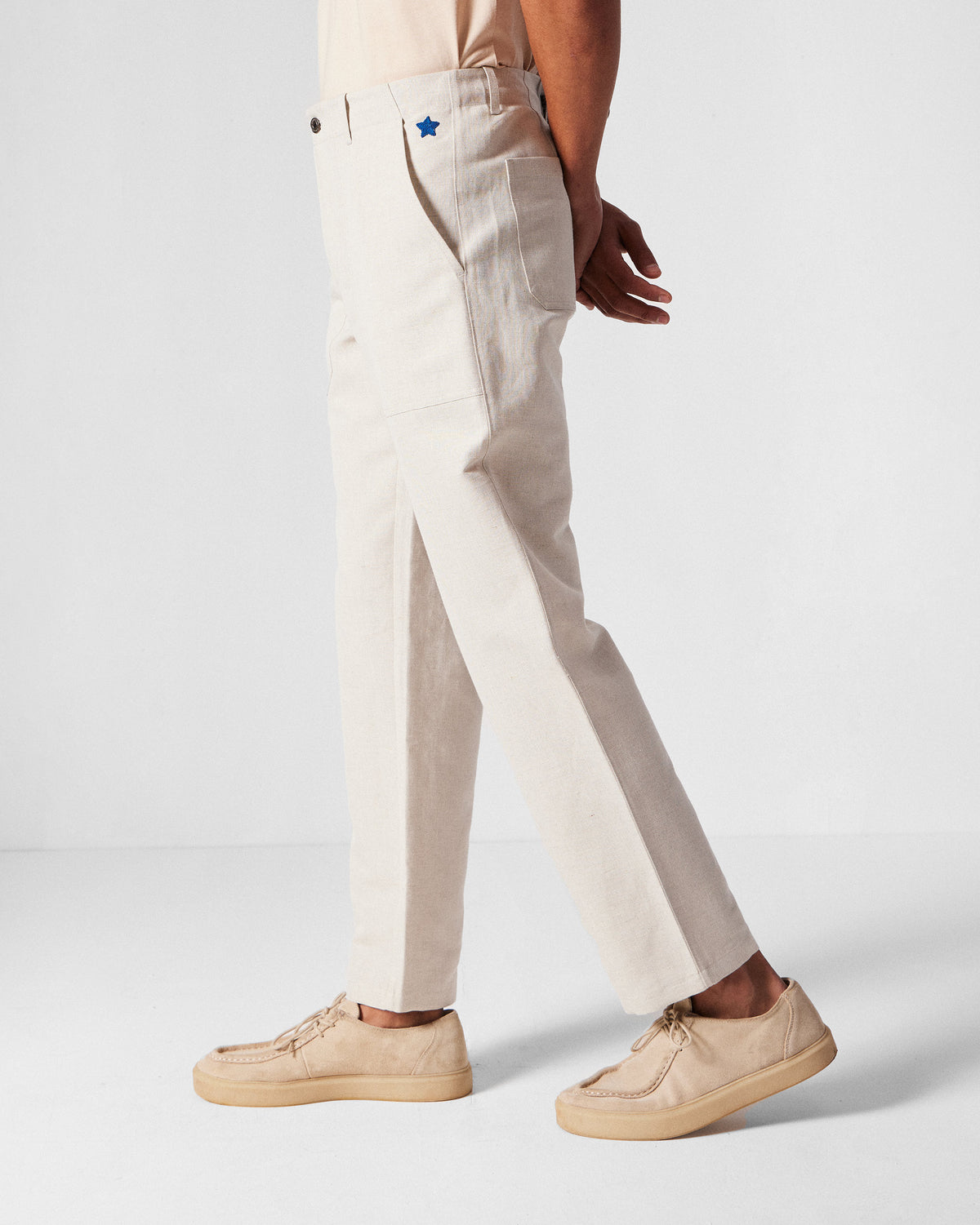 Side view of ivory Zar Pants showing a blue star at the pocket.