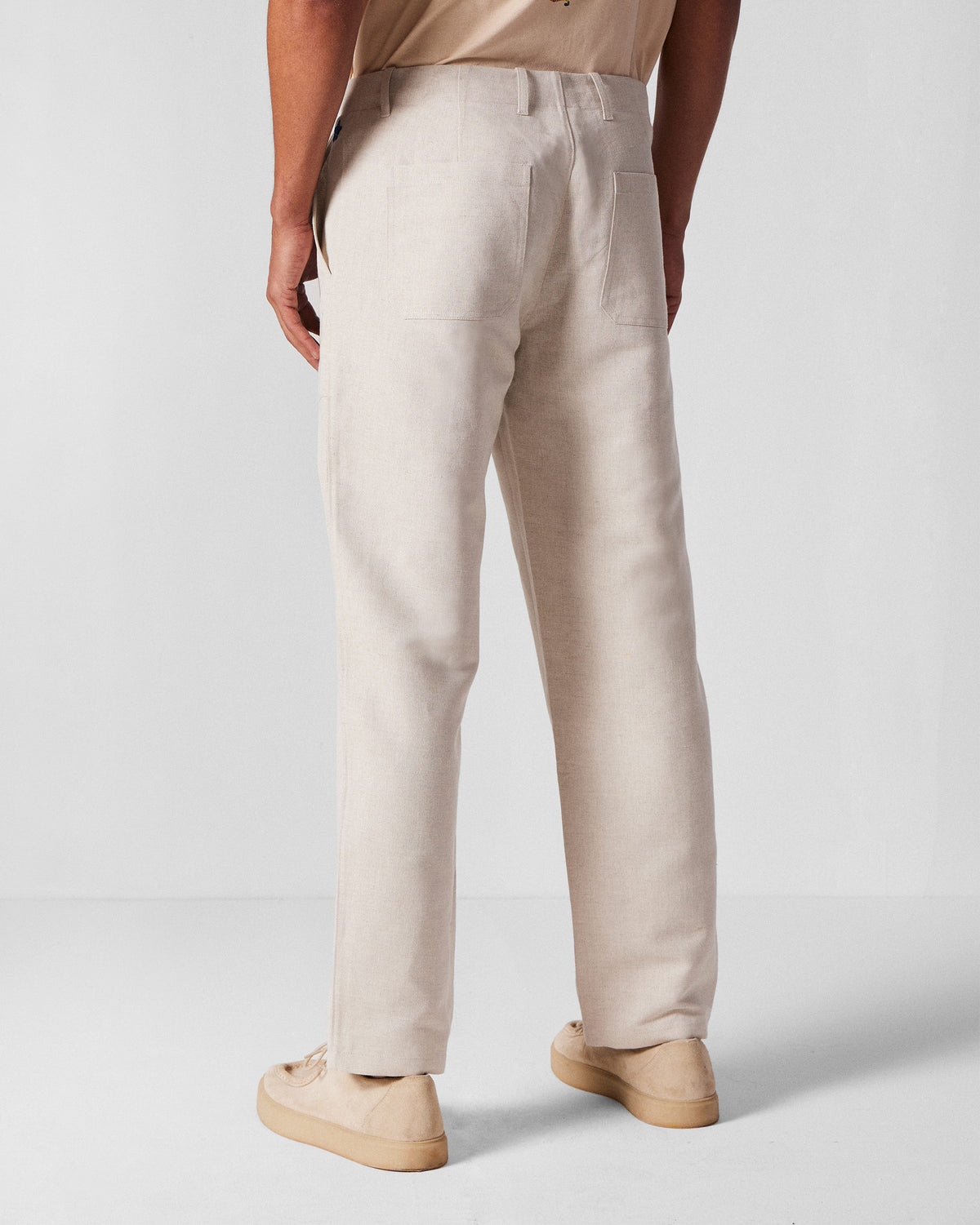 Back of ivory Zar Pants with patch pockets worn by a person.