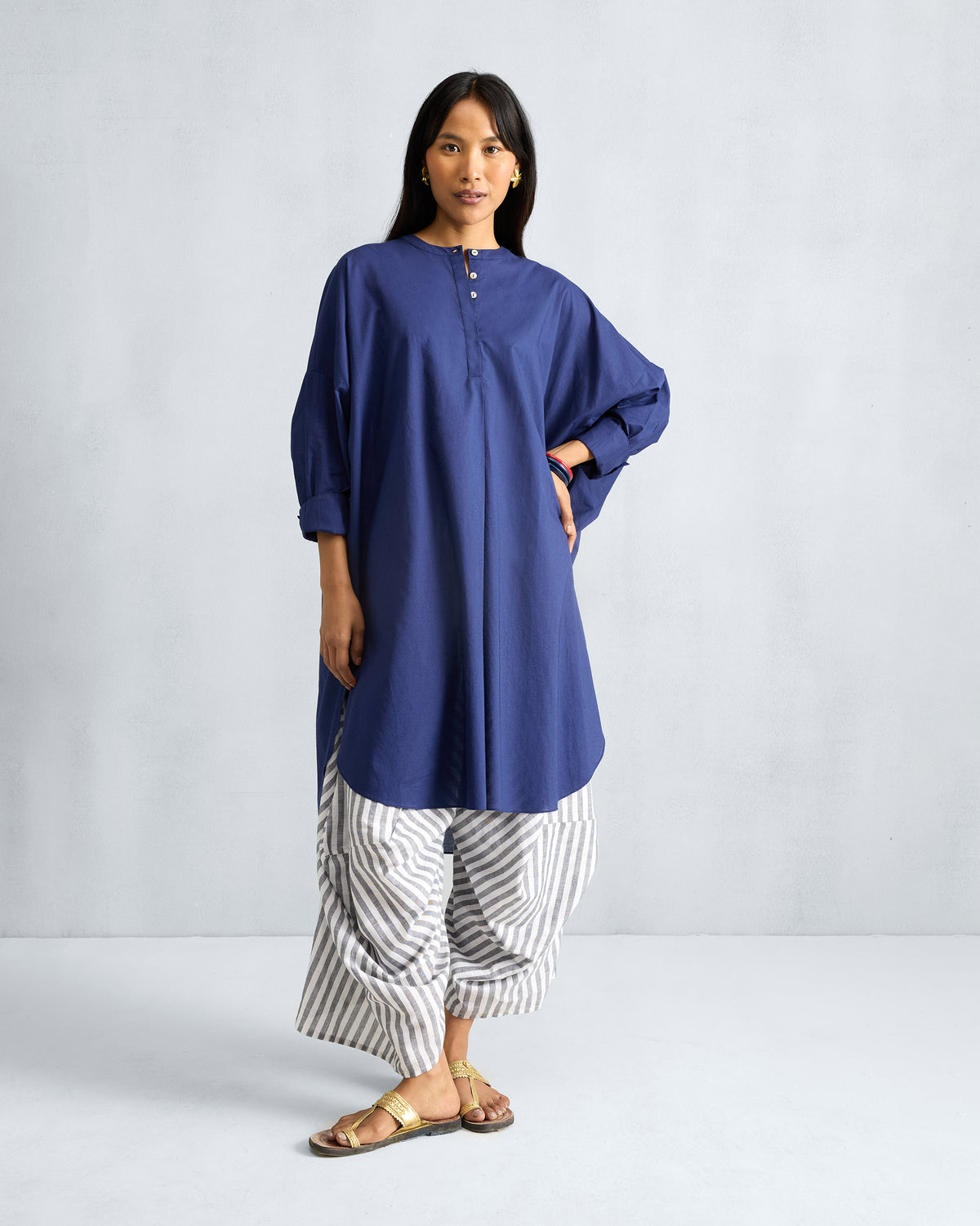 Person wearing an ink blue Lazy Sunday tunic with a mandarin collar.
