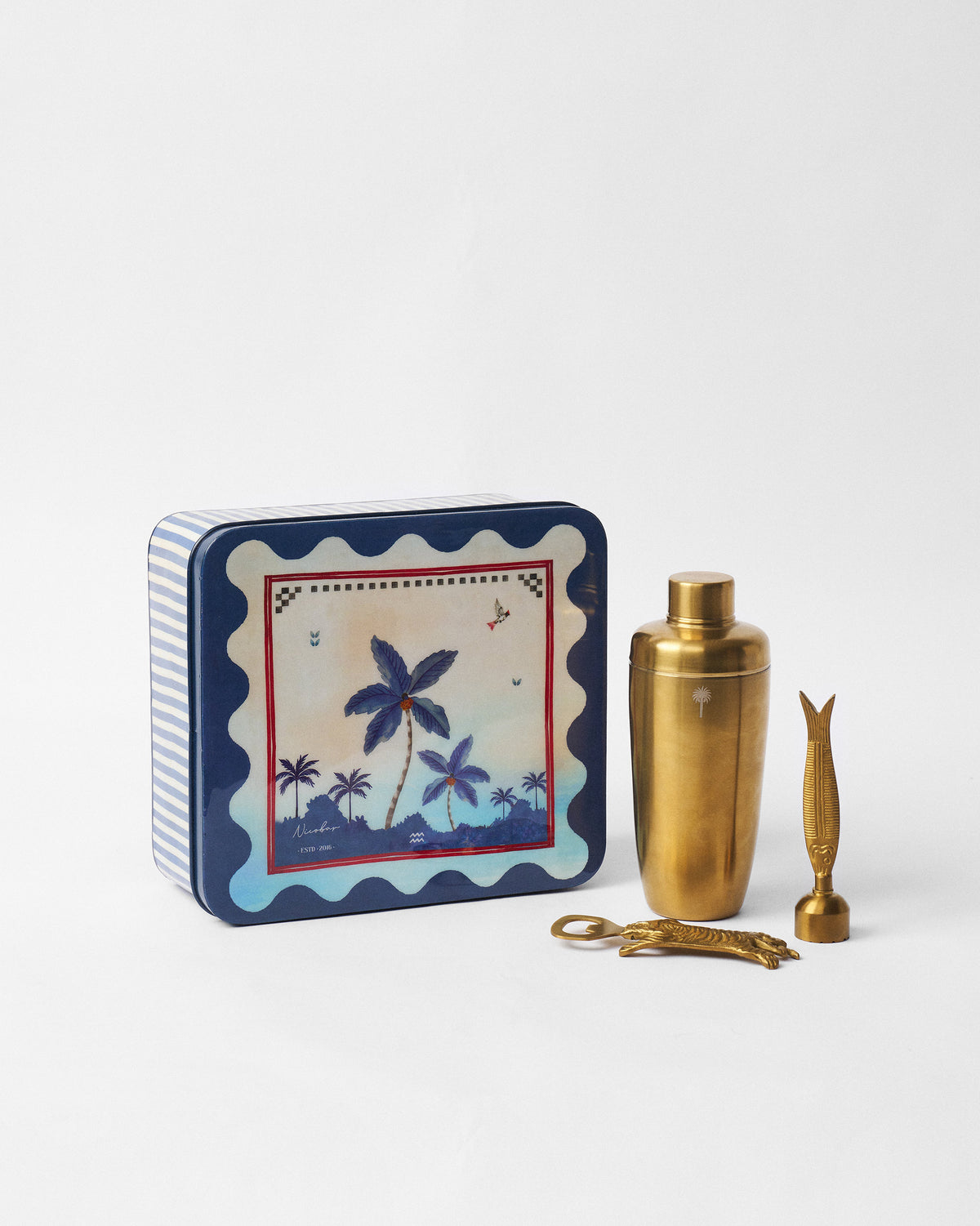Kandy Stripes Barware Gift Set with gold tools beside a palm-print striped tin.