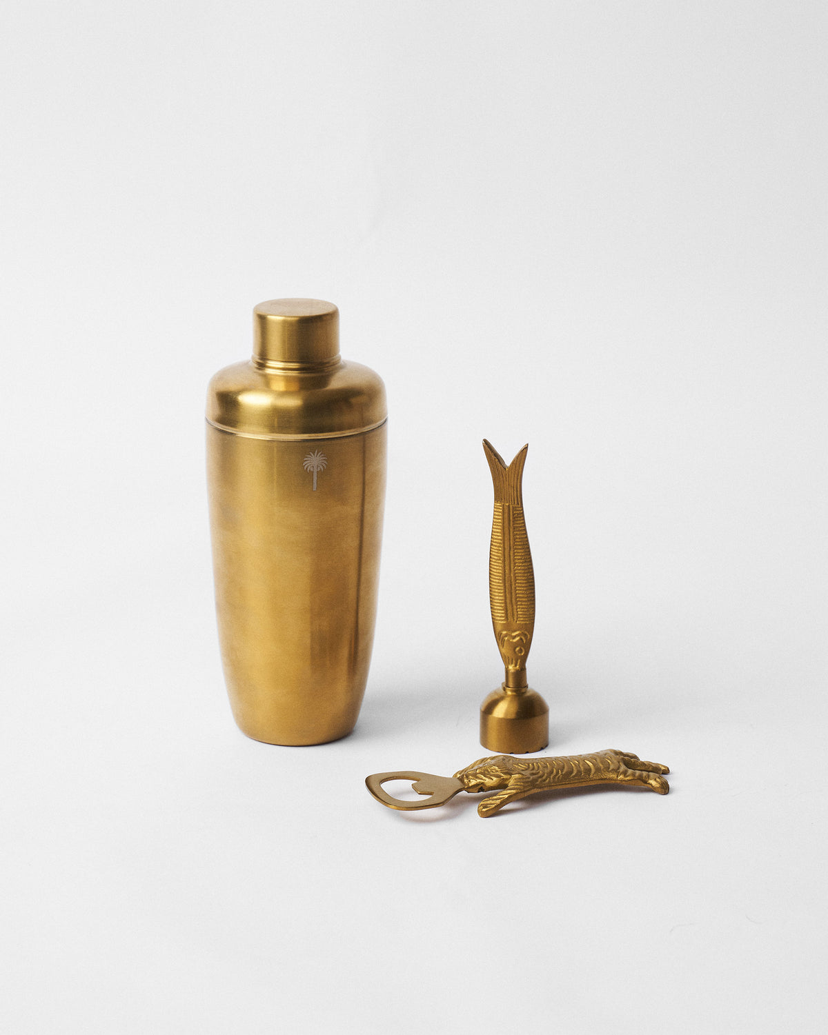 Gold cocktail shaker, fish muddler and tiger bottle opener from the Kandy Stripes set.