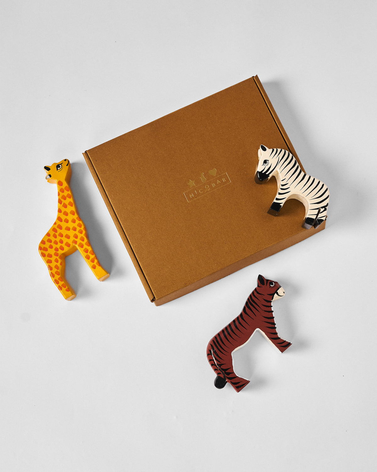 Nicofari gift set with a giraffe, zebra and tiger beside a kraft box.