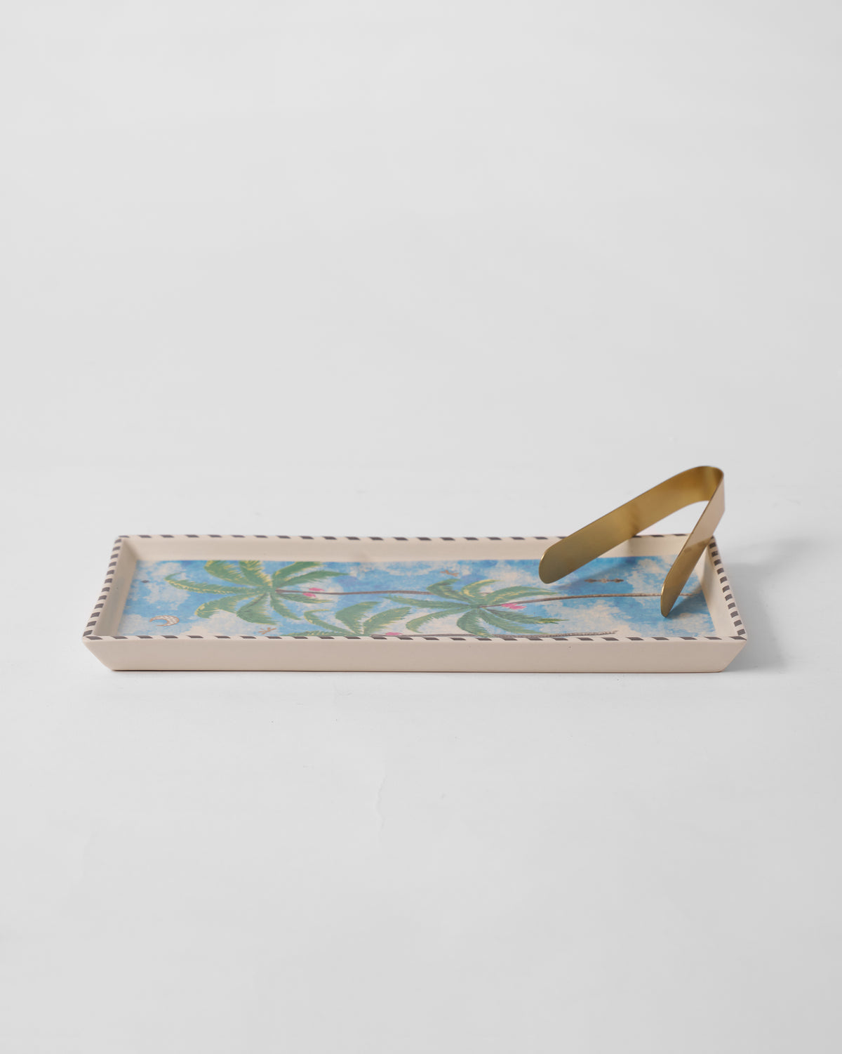 Haathi cookie tray with palm print, striped rim, and gold tongs resting on top.