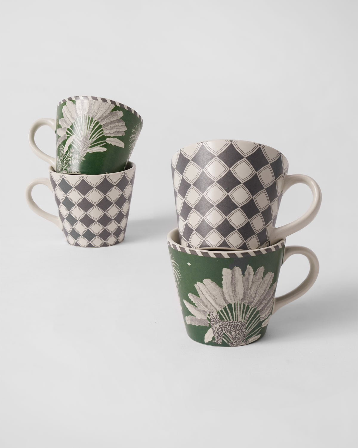 Kandy espresso mugs stacked to show palm, leopard, and diamond motifs.