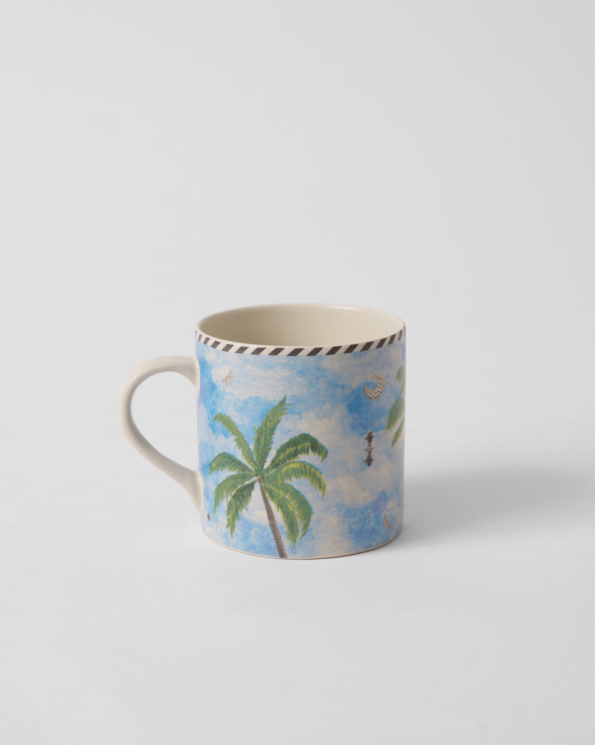 Side view of Kandy Straight Mug with palm trees on a blue sky print.
