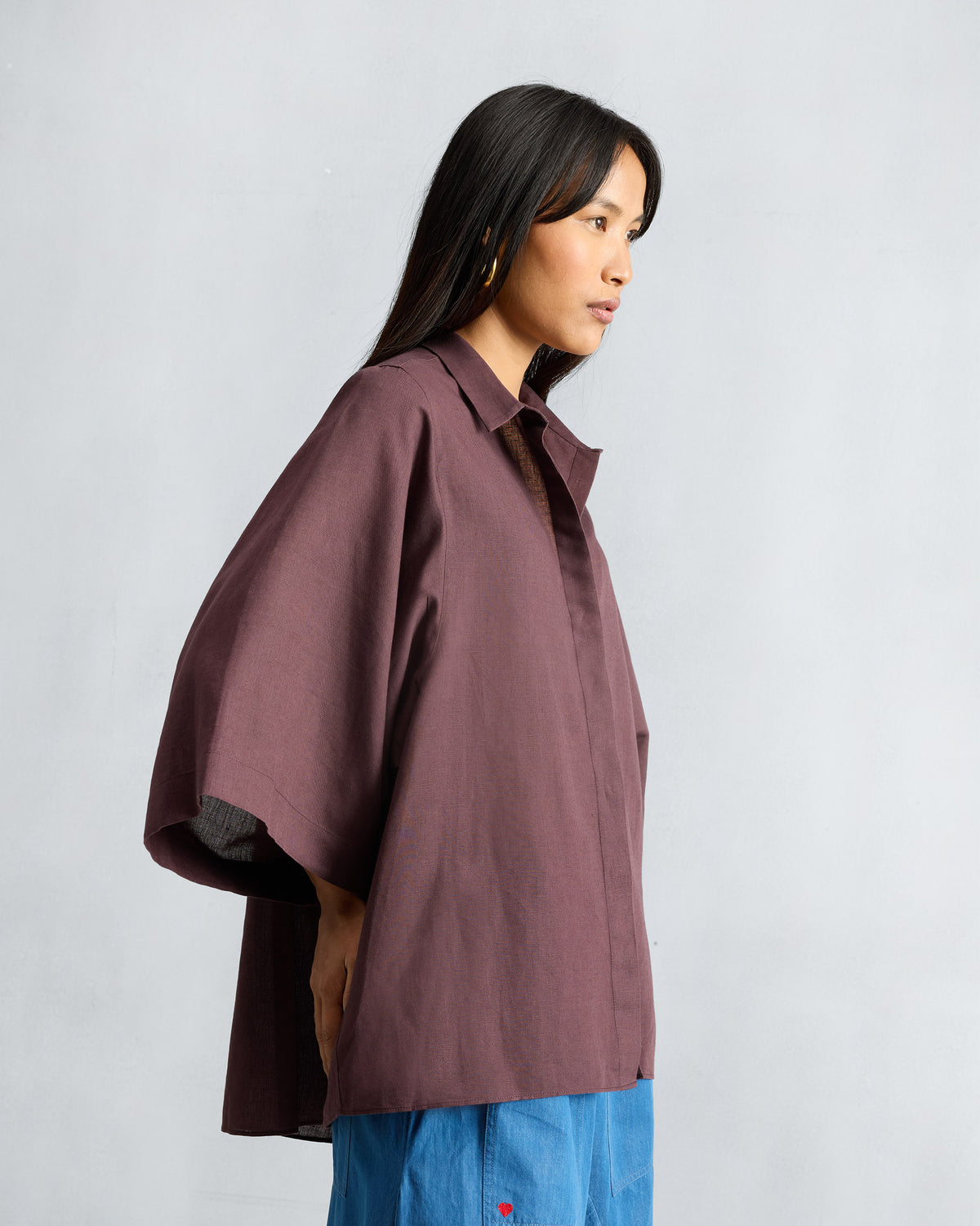Side view of a chocolate plum Drop Armhole Shirt with wide sleeves.