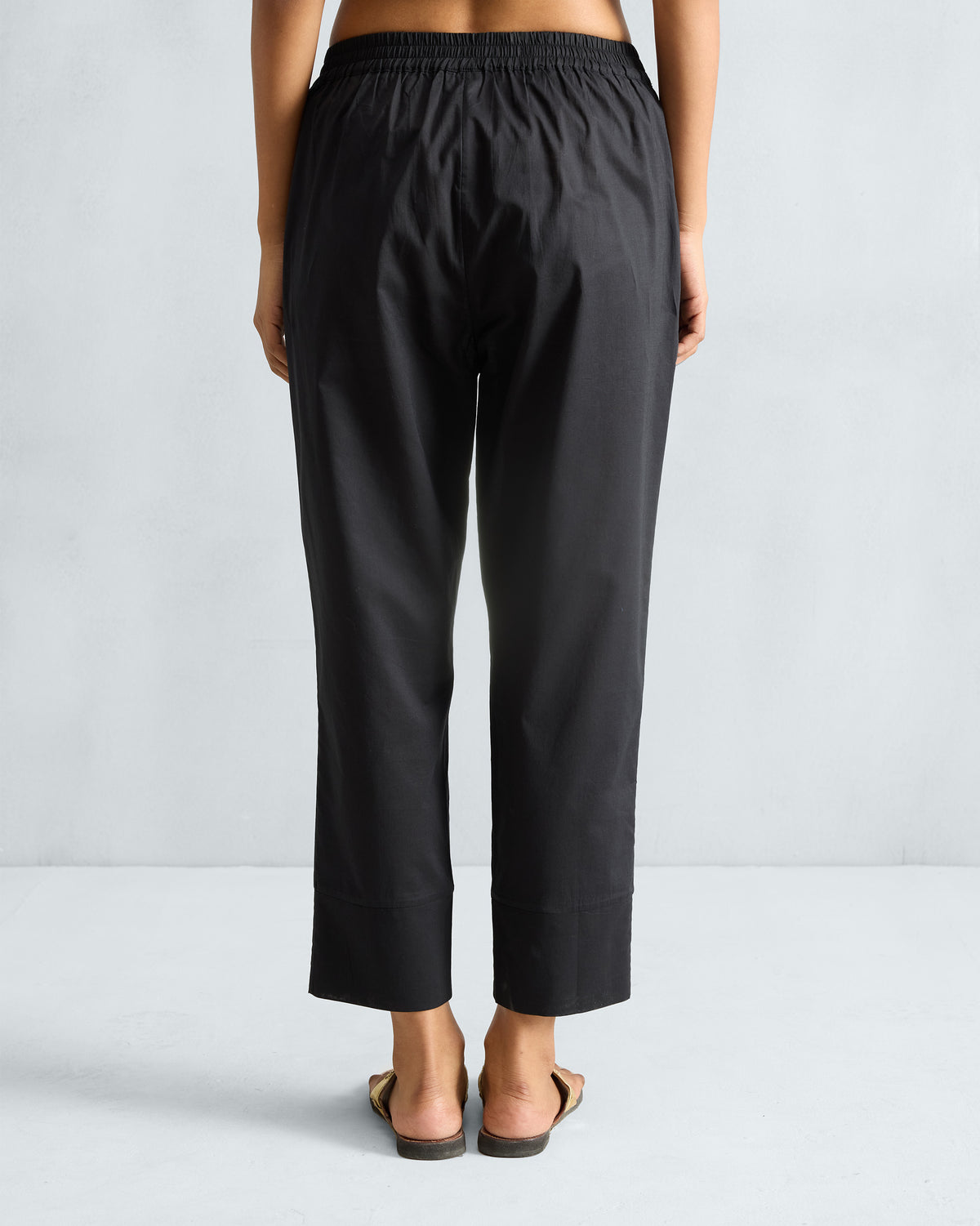 Back of black Narrow pants with an elastic waist and wide hem.