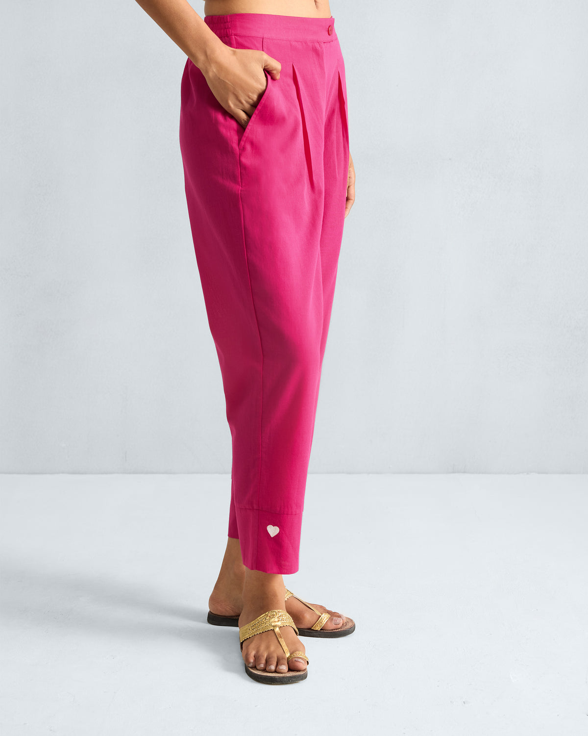 Side view of fuchsia Narrow Pants with a white heart near the hem.
