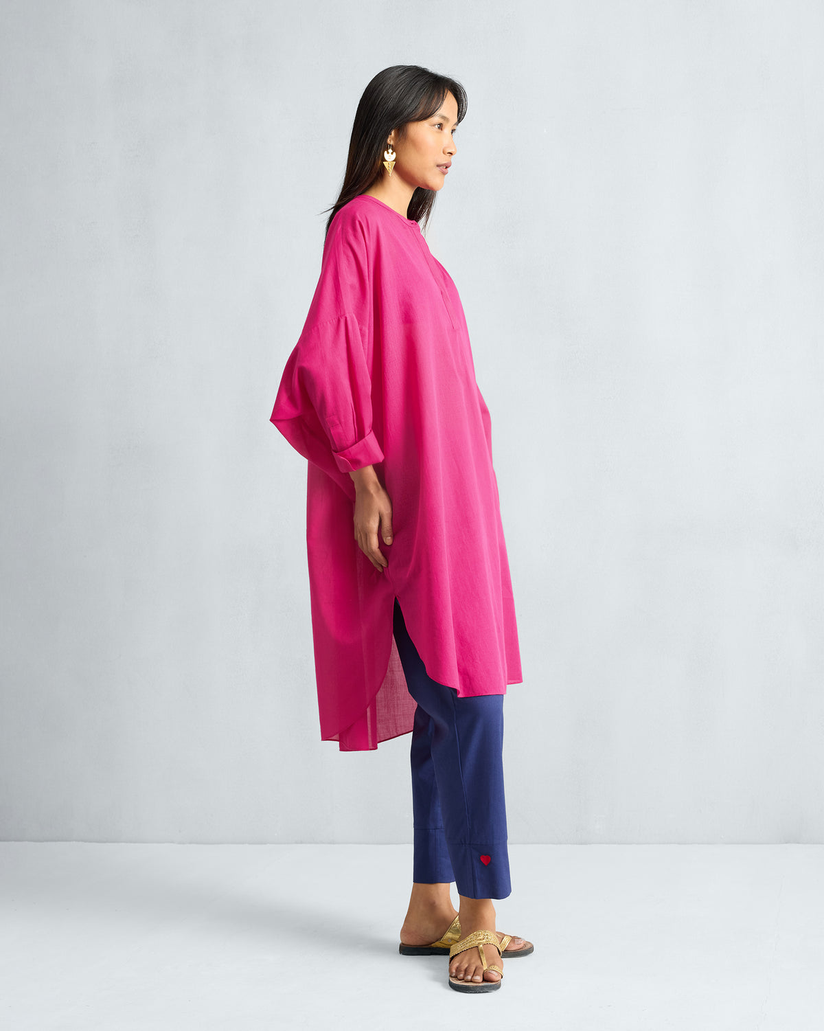 Side view of a fuchsia Lazy Sunday tunic with a curved hem.