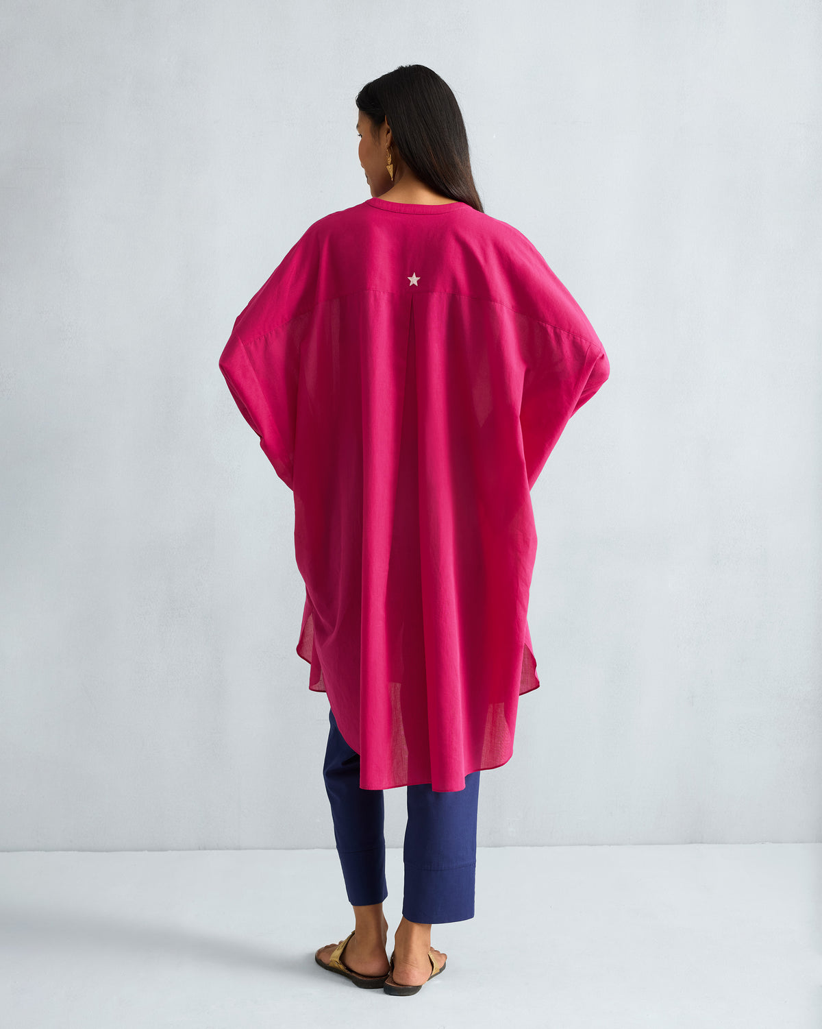 Back of a fuchsia Lazy Sunday tunic with a white star on the yoke.