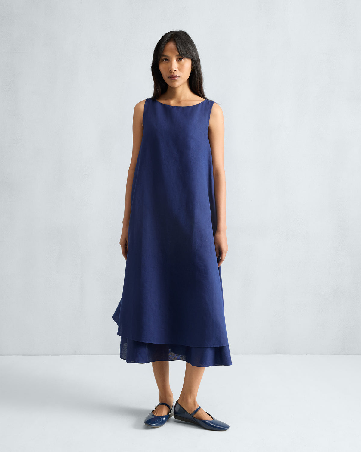 Person wearing an ink blue Double Layer Dress with a tiered hem.