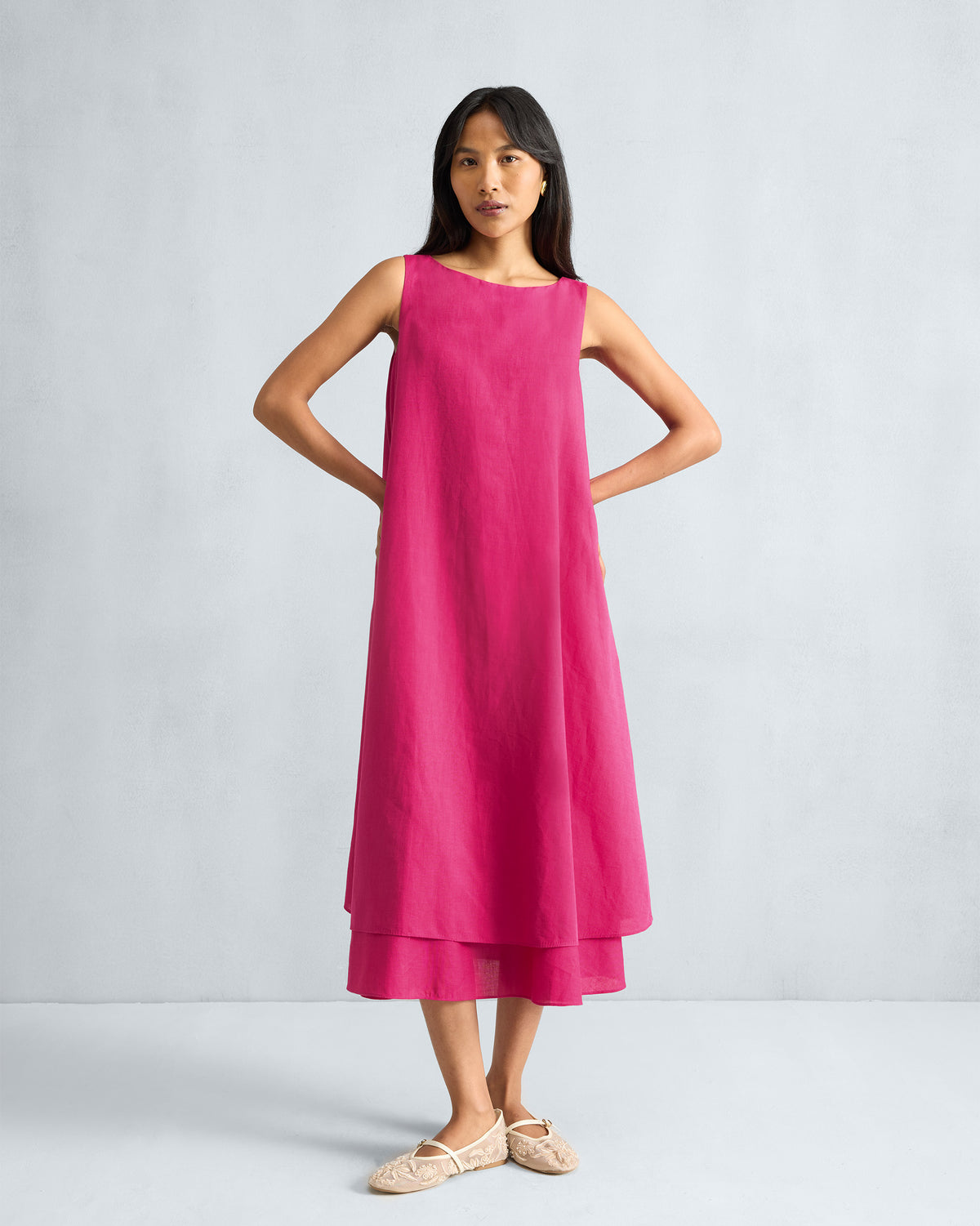 Person wearing a fuchsia sleeveless midi dress.